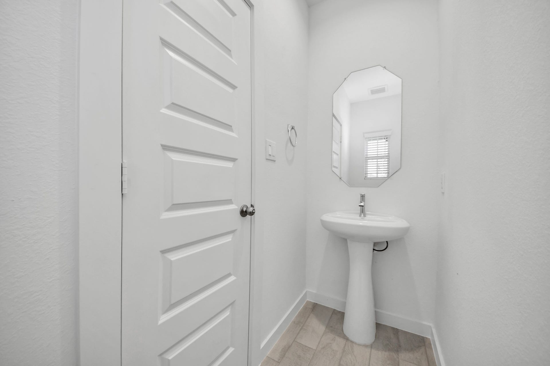 18551 Athena Flower Drive, Fresno, TX 77545 This half bathroom features a stylish pedestal sink, modern hardware, and bright recessed lighting, creating a sleek and inviting space. Sample photo of completed home with similar floor plan. Actual colors and selections may vary.