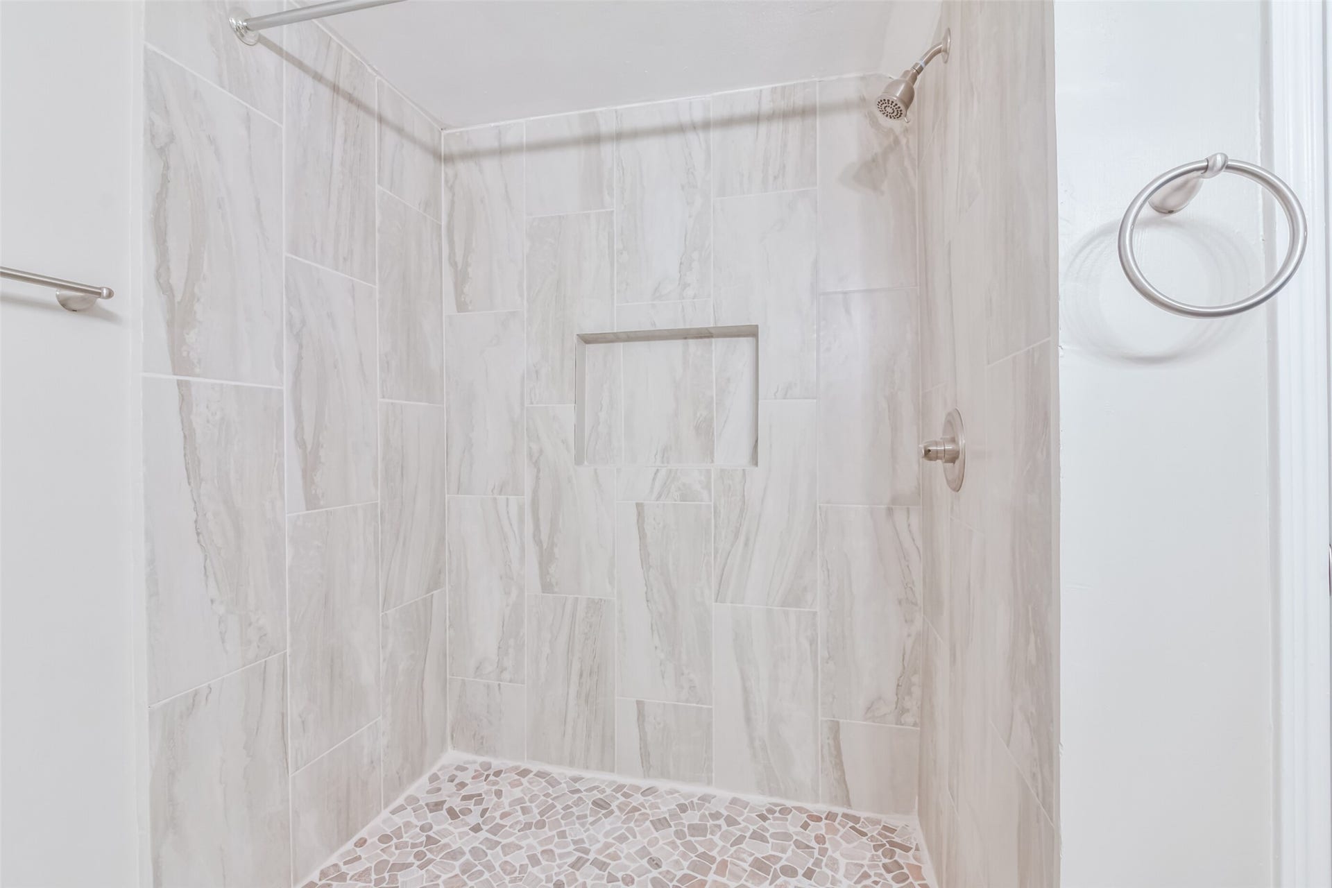 Walk-in shower with decorative tile finishes.
