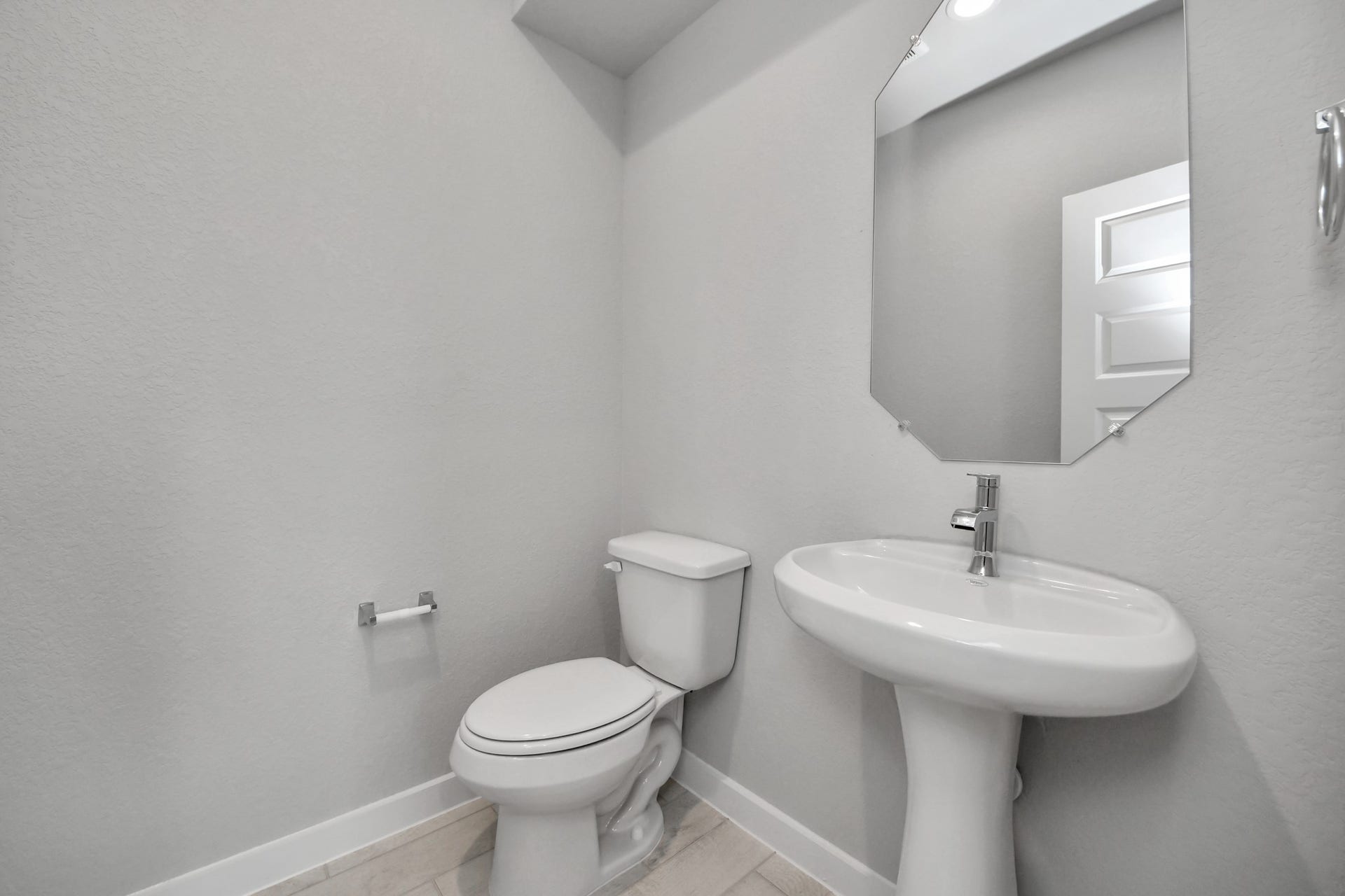 11115 Tulip Ridge Trail, Houston, TX 77044 This half bathroom features a stylish pedestal sink, modern hardware, and bright recessed lighting, creating a sleek and inviting space. Sample photo of completed home with similar floor plan. Actual colors and selections may vary.