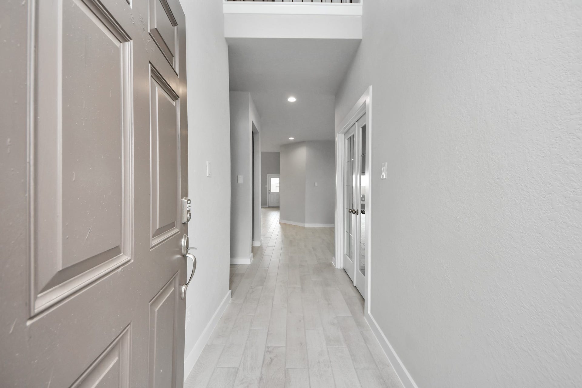 11115 Tulip Ridge Trail, Houston, TX 77044 As you step into the threshold of this luxurious home, you'll soon be welcomed by an elegant glass door (to be installed). Inside, soaring ceilings amplify the spaciousness, while the refined wood-look tile flooring and oversized baseboards exude sophistication and charm. Sample photo of completed home with similar floor plan. Actual colors and selections may vary.
