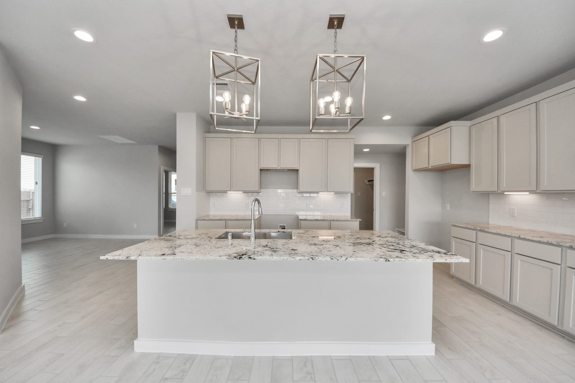 11115 Tulip Ridge Trail, Houston, TX 77044 This kitchen is by far any chefs dream! This spacious kitchen features high ceilings, light stained wood cabinets, granite countertop, SS appliances, modern tile backsplash, recessed lighting, extended counter space, granite kitchen island with double sink, and space for breakfast bar, and a walk-in pantry all overlooking your huge family room. Sample photo of completed home with similar floor plan. Actual colors and selections may vary.