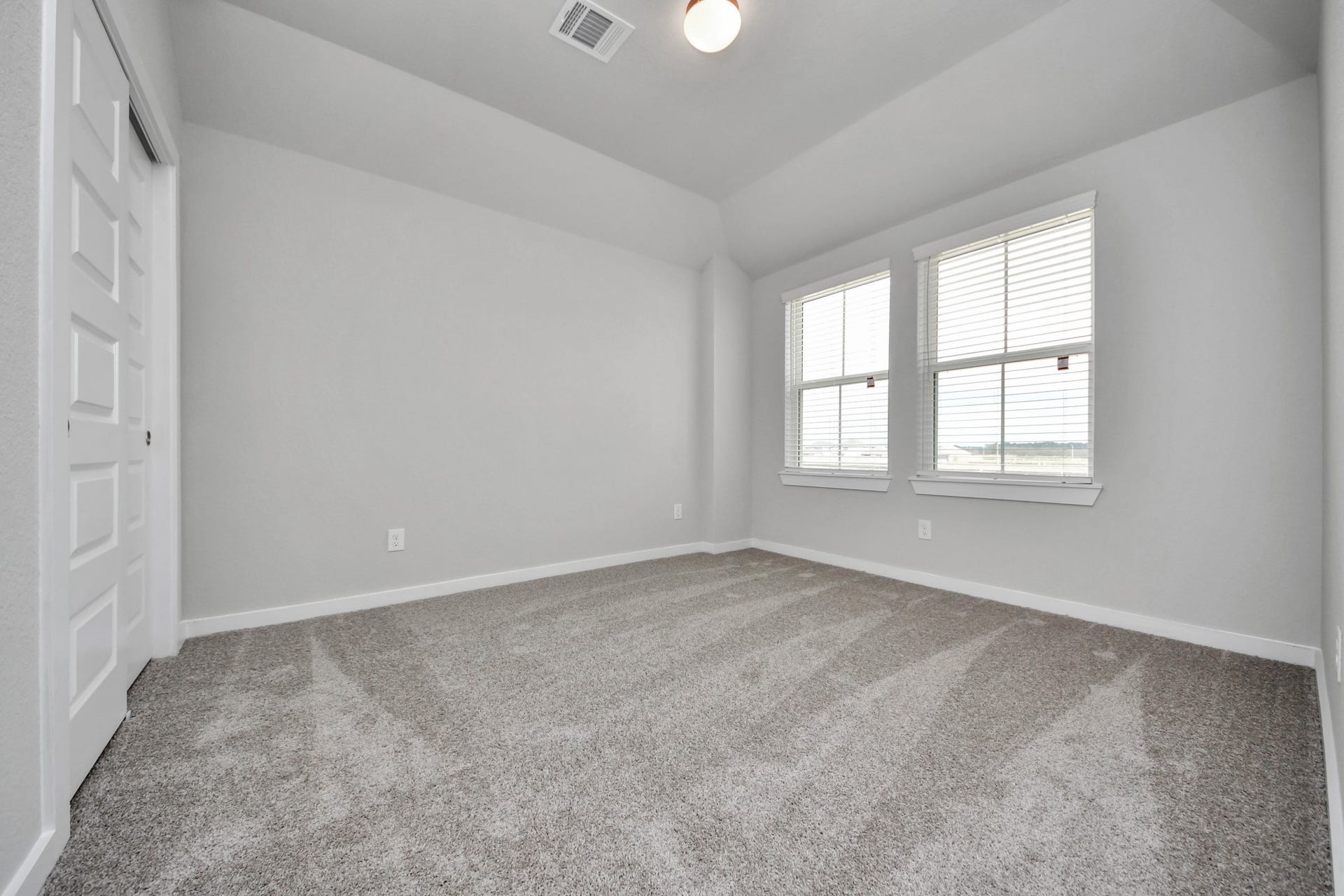 11115 Tulip Ridge Trail, Houston, TX 77044 Secondary bedroom features plush carpeting, large windows that let in plenty of natural light, bright paint, and spacious closets. Sample photo of completed home with similar floor plan. Actual colors and selections may vary.