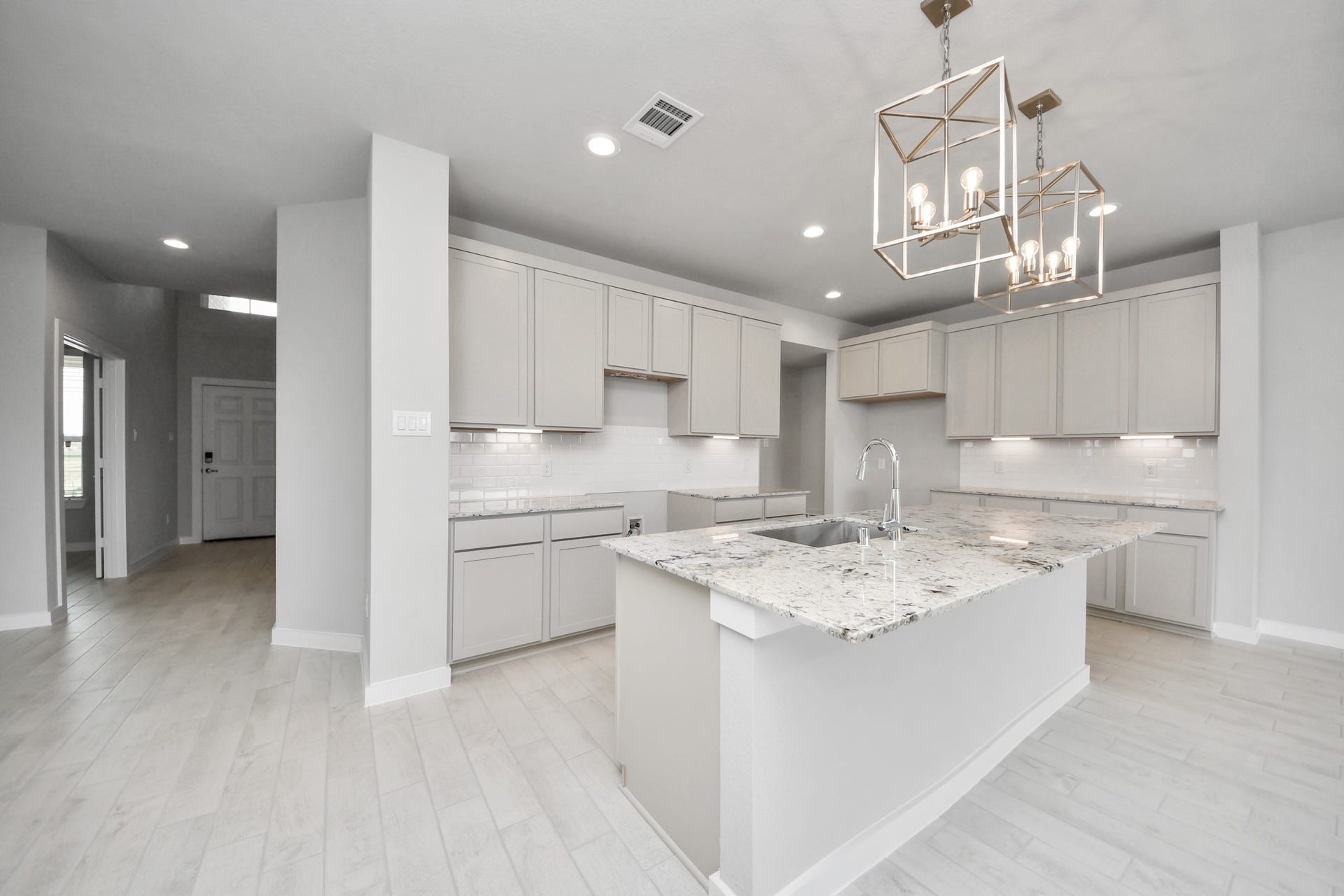 11115 Tulip Ridge Trail, Houston, TX 77044 This kitchen is truly a chef's dream! This haven Boasts high ceilings, recessed & pendant lighting, stained wood cabinets, granite countertops, stainless steel appliances, a modern tile backsplash. All of this overlooks your expansive family room, creating a perfect space for culinary delights and family gatherings. Sample photo of completed home with similar floor plan. Actual colors and selections may vary.