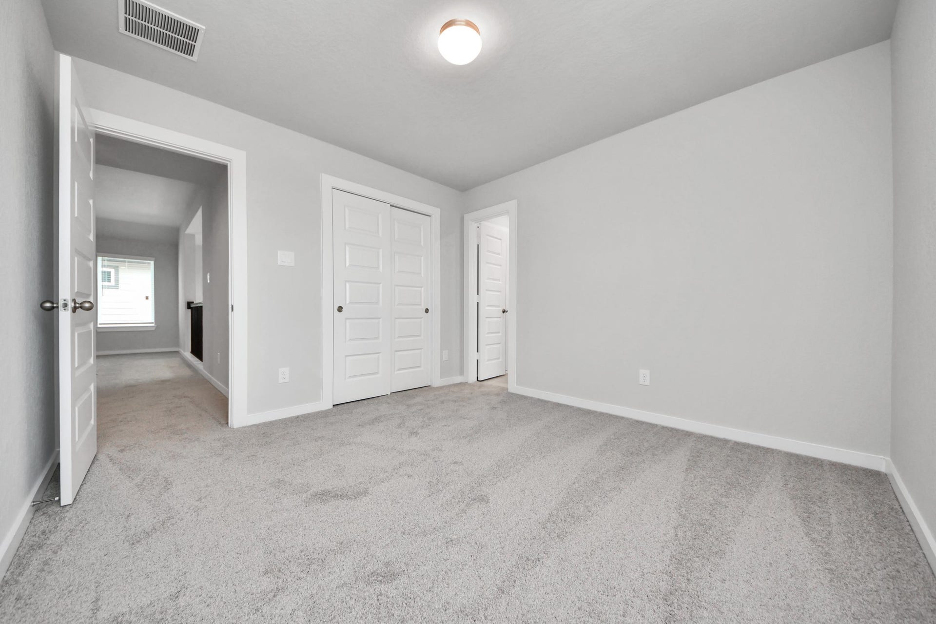 11115 Tulip Ridge Trail, Houston, TX 77044 Secondary bedroom features plush carpeting, large windows that let in plenty of natural light, bright paint, and spacious closets. Sample photo of completed home with similar floor plan. Actual colors and selections may vary.