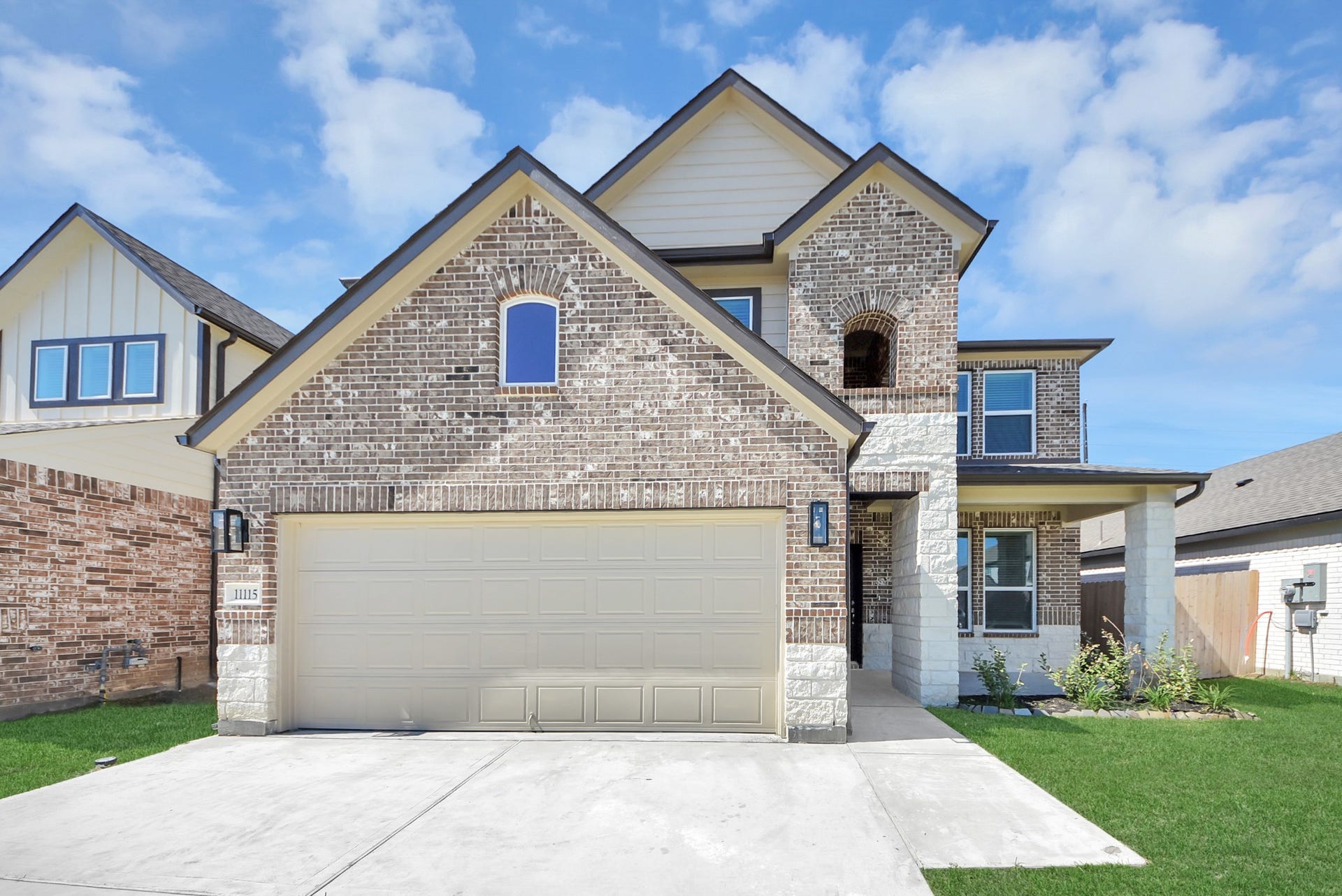 11115 Tulip Ridge Trail, Houston, TX 77044 Meticulously maintained yard and lush landscape, paired with a premium elevation featuring captivating brick accents. Modern coach lights add a touch of contemporary elegance to the exterior.