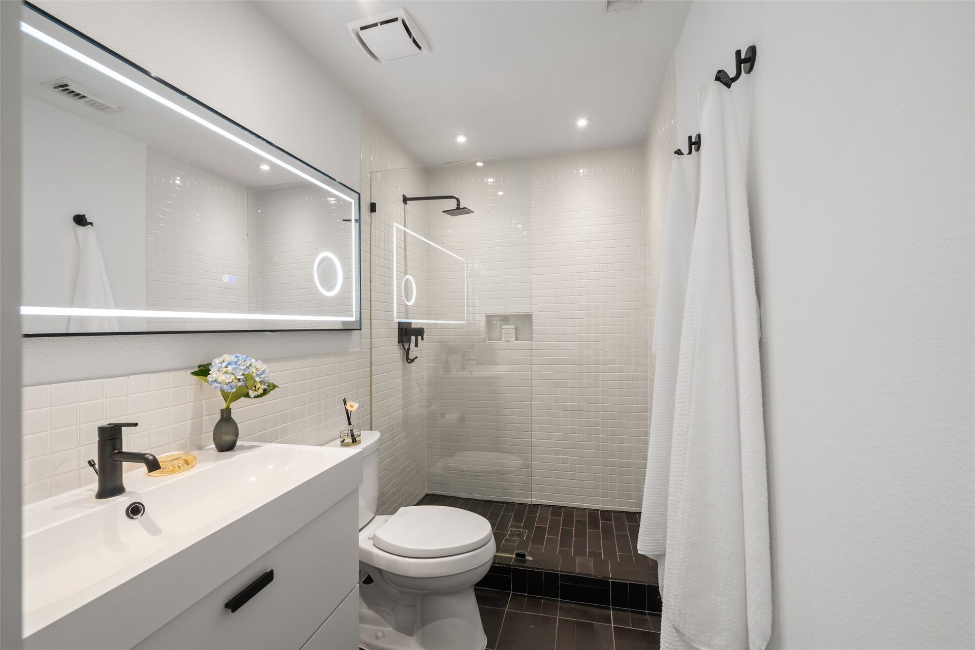 258 Sentry Maple Place, The Woodlands, TX 77382 The updated secondary bathroom features a sleek walk-in shower, modern fixtures and contemporary tile for a clean spa-like feel.