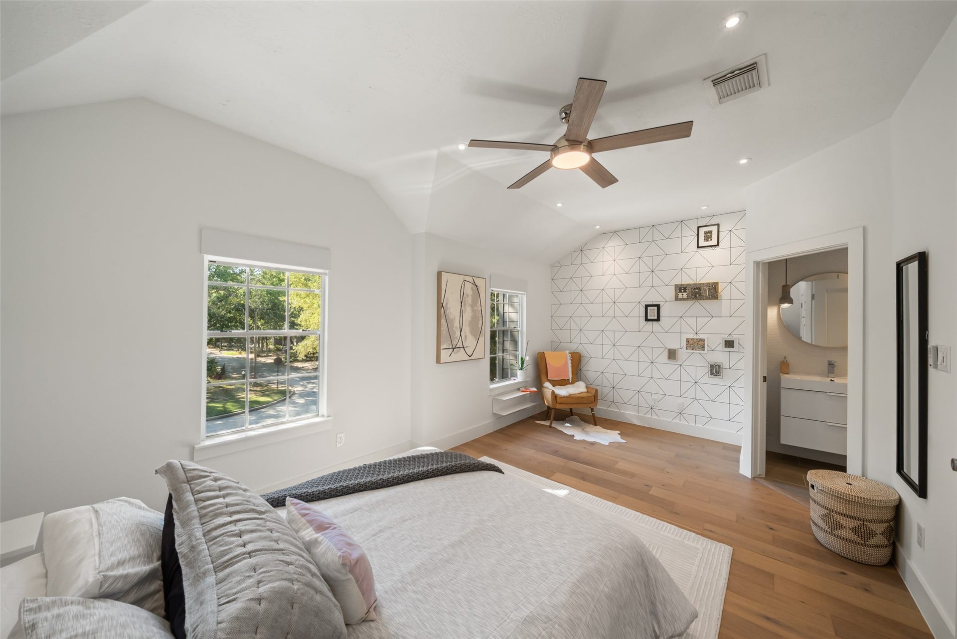258 Sentry Maple Place, The Woodlands, TX 77382 The spacious primary suite features vaulted ceilings, wood floors and queen size bed, creating a serene retreat with abundant natural light.