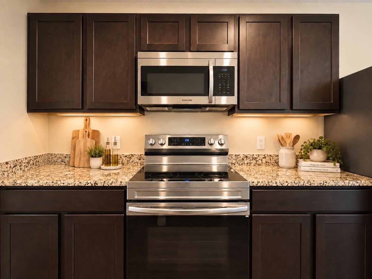 Stainless steel range and microwave are complemented by granite countertops and rich cabinetry.