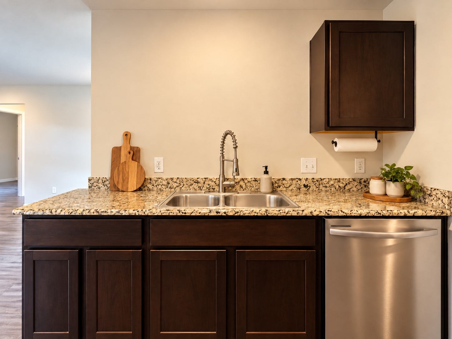 Double basin sink, pull down faucet, granite countertops, and ample cabinetry provide practical workspace.