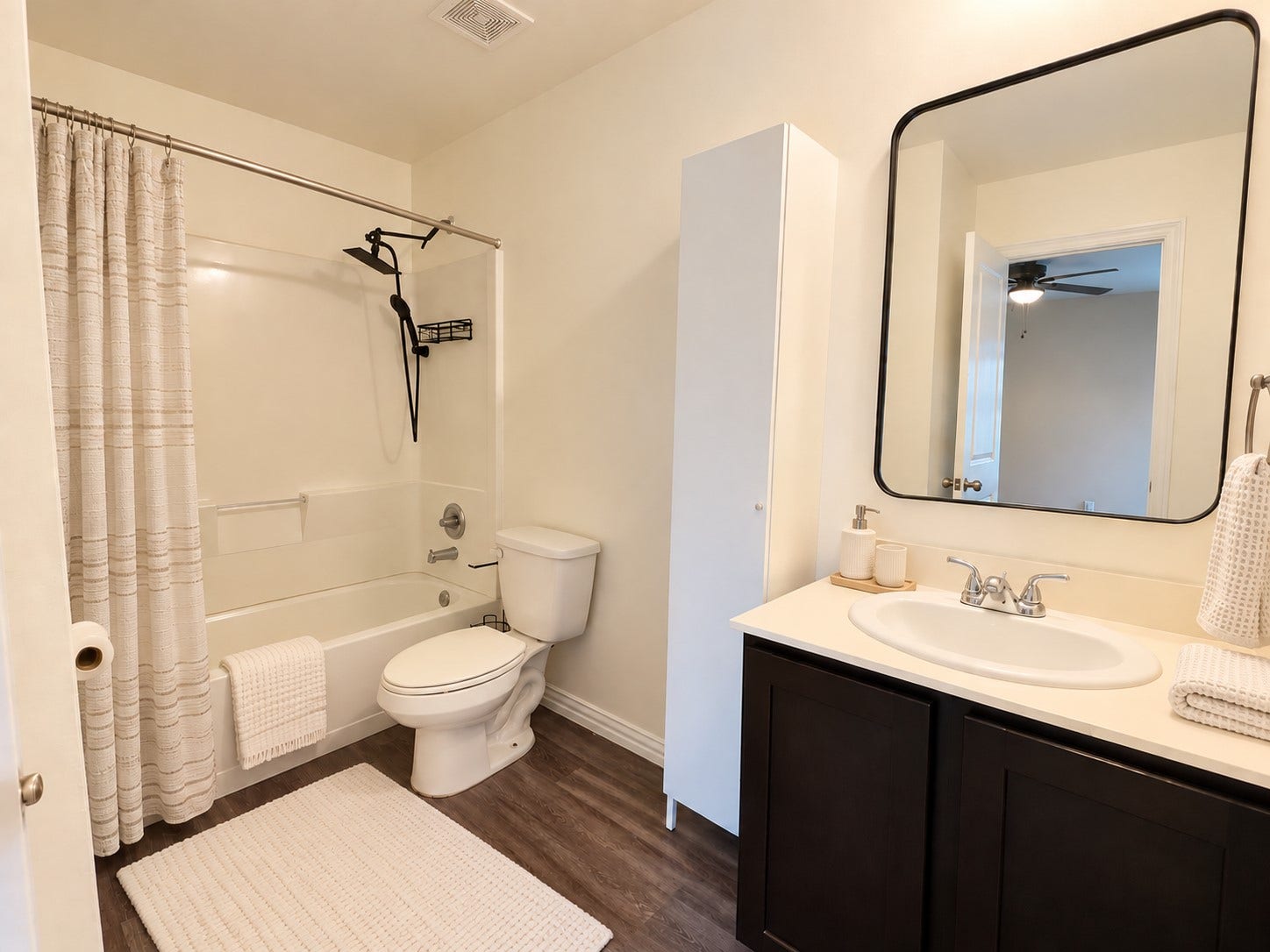 Private primary bath featuring a tub and shower combination, vanity, and additional storage.