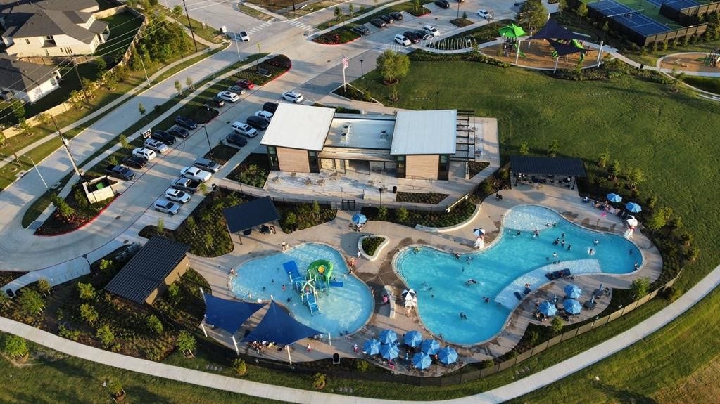 29651 Bur Creek Lane, Fulshear, TX 77441 THE LANDING amenity center is within walking distance of the home and features pools, a splash pad, and a water slide, along with adjacent tennis courts and a playground.