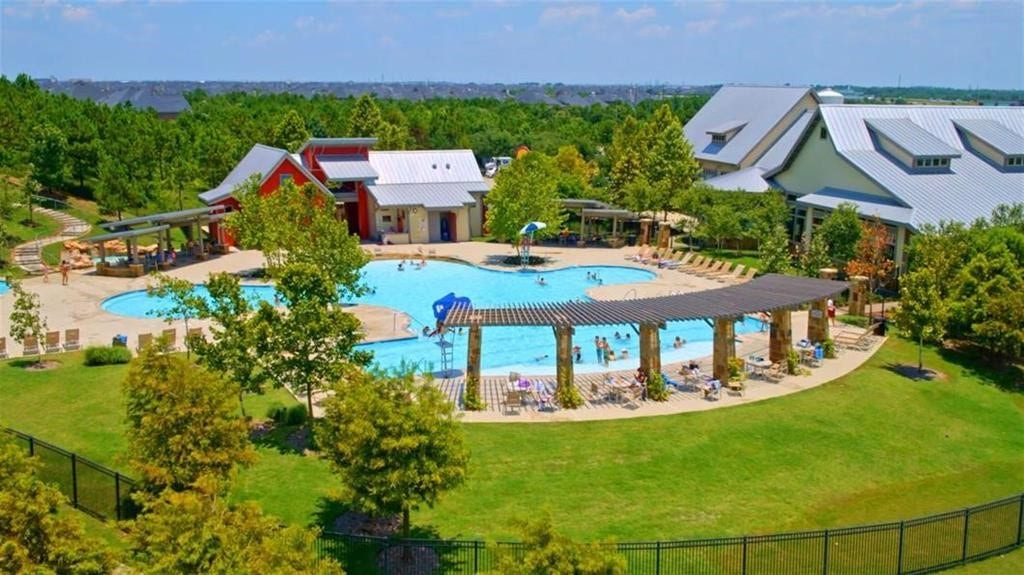 29651 Bur Creek Lane, Fulshear, TX 77441 Experience resort-style living with a stunning community pool, surrounded by lush greenery and modern amenities, perfect for relaxation and entertainment.
