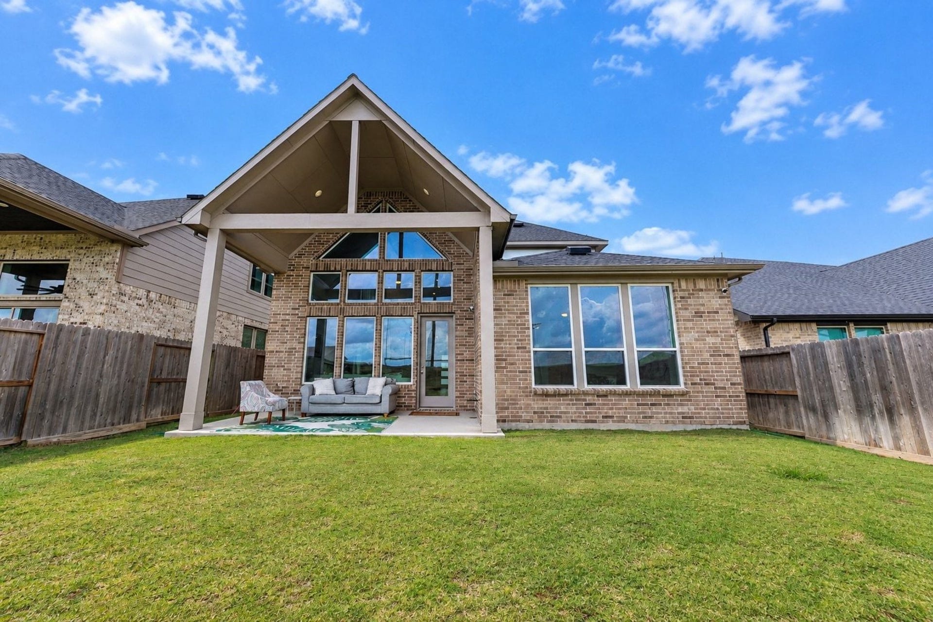 29651 Bur Creek Lane, Fulshear, TX 77441 Spacious backyard with a two story covered patio and elegant brick exterior, perfect for outdoor entertaining.