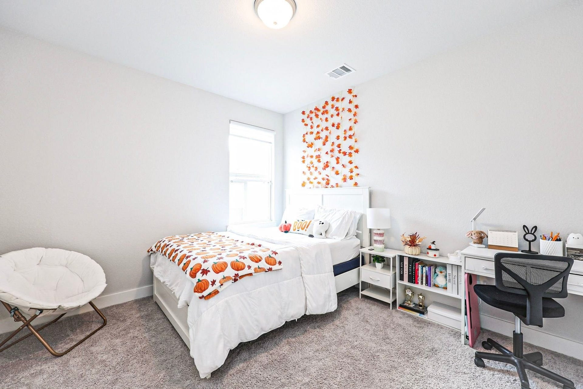 29651 Bur Creek Lane, Fulshear, TX 77441 Third bedroom upstairs with one large window features a comfortable bed with playful decor, a functional desk space, and soft carpet flooring, perfect for relaxation and productivity. The room is spacious.