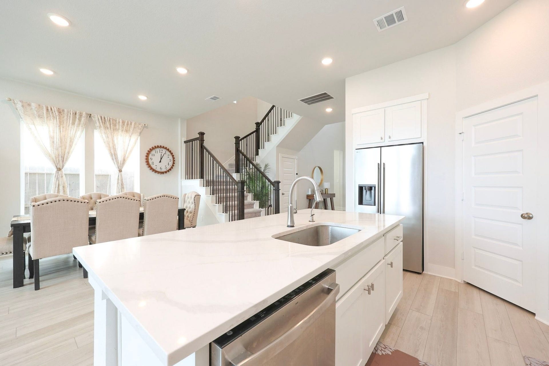 29651 Bur Creek Lane, Fulshear, TX 77441 The spacious kitchen features a pantry and a dedicated refrigerator alcove. An elegant staircase with black iron balusters creates a grand and inviting entrance.