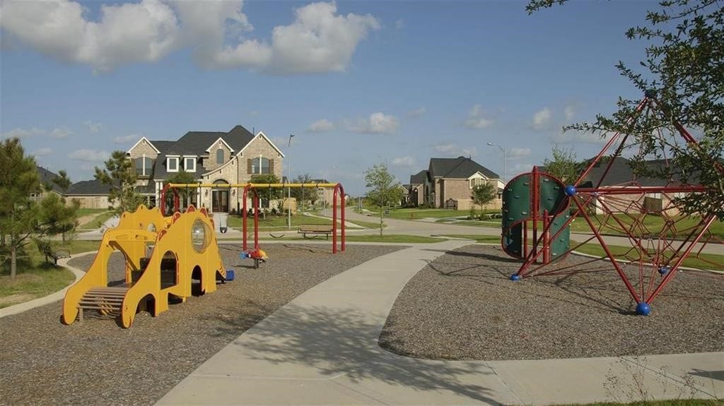 29651 Bur Creek Lane, Fulshear, TX 77441 The neighborhood playground with modern equipment, surrounded by well-maintained homes and lush greenery, perfect for family living.