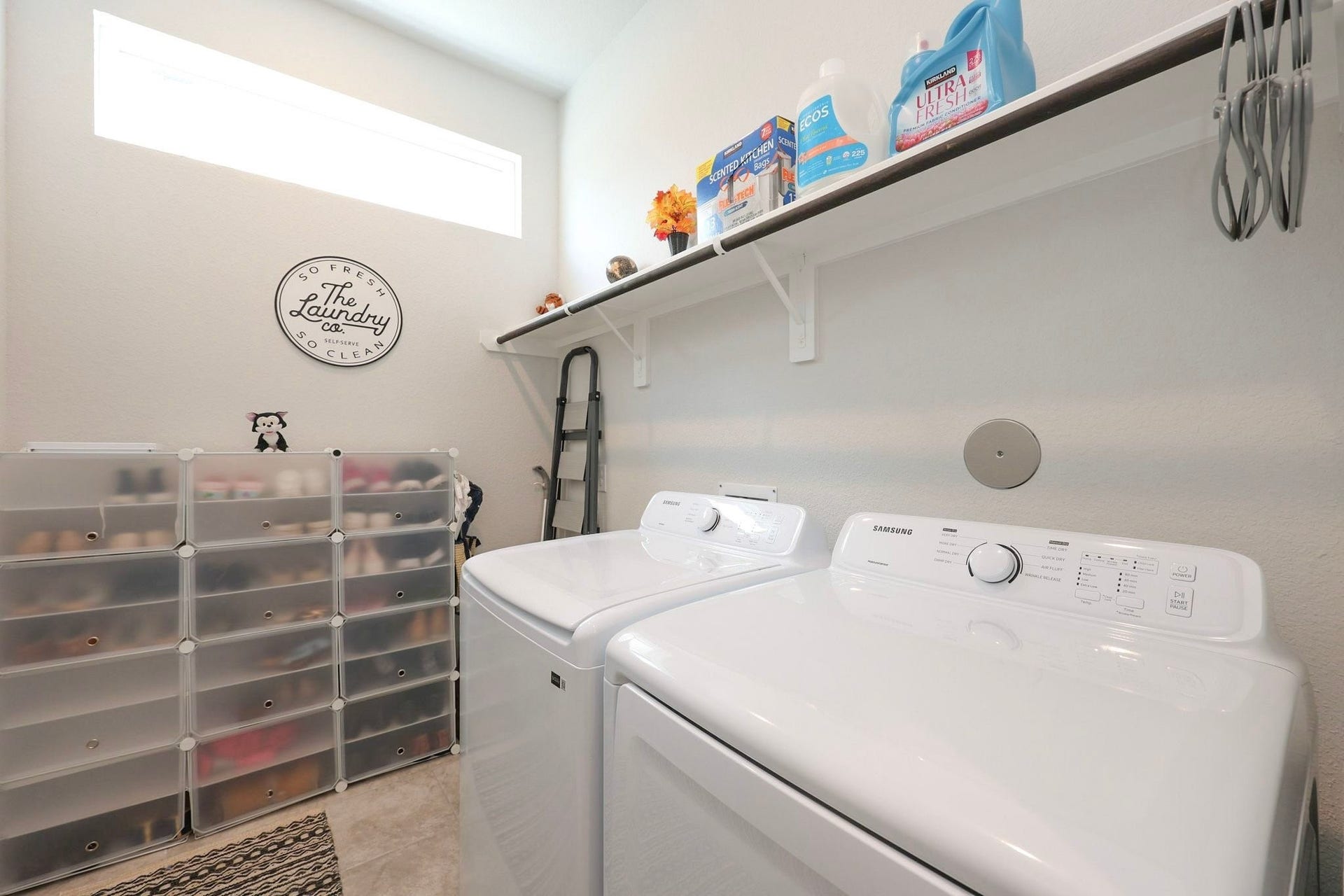 29651 Bur Creek Lane, Fulshear, TX 77441 Bright and organized laundry room on 1st floor featuring modern appliances, ample shelving for storage, and natural light from a high window.