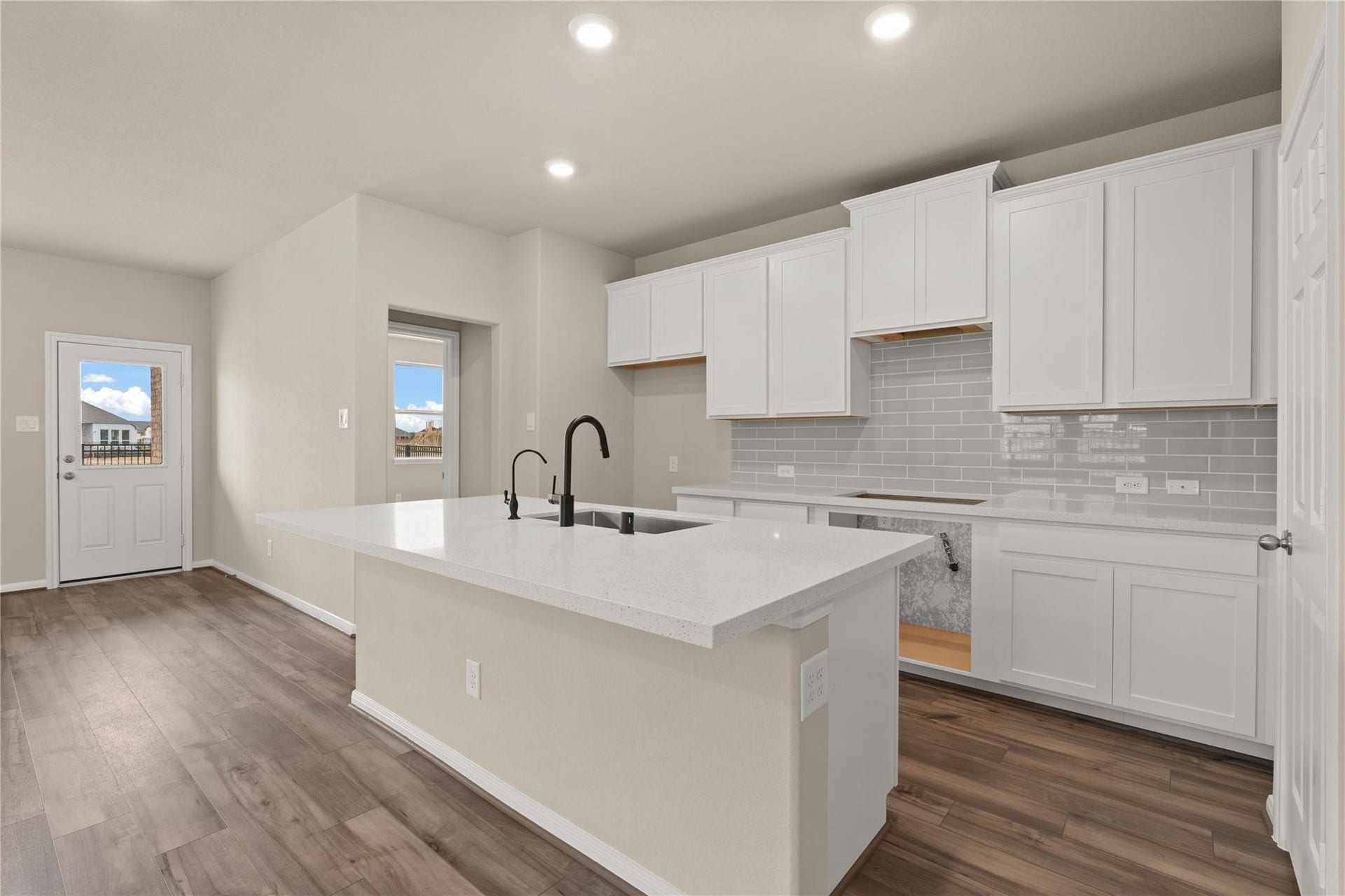 2459 Solaris Bend Drive, Katy, TX 77493 This light and bright kitchen features a large quartz island, white stained cabinets, a large sink over looking your family room, recessed lighting, and beautiful backsplash.