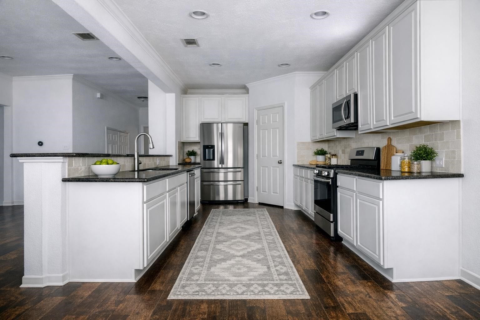 AI Staged photo of the open
concept kitchen with island, lots of
cabinet space, modern finishes and
stone backsplashes. (A Refrigerator will be included but not as shown).