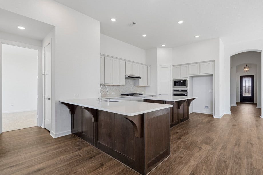 6430 Mahogany Branch Trail, Manvel, TX 77578 Kitchen has an island and a peninsula .