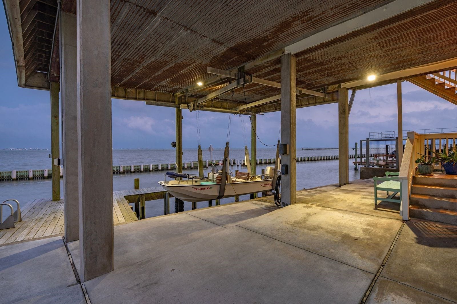 12 Tiki Circle, Tiki Island, TX 77554 Enjoy Your Boat Day or Night! Property boasts concrete bulkhead with boat house/decking and lift featuring 9 "wellers" for the pier; enjoy fishing Galveston Bay with deep water access direct to the Gulf of America.