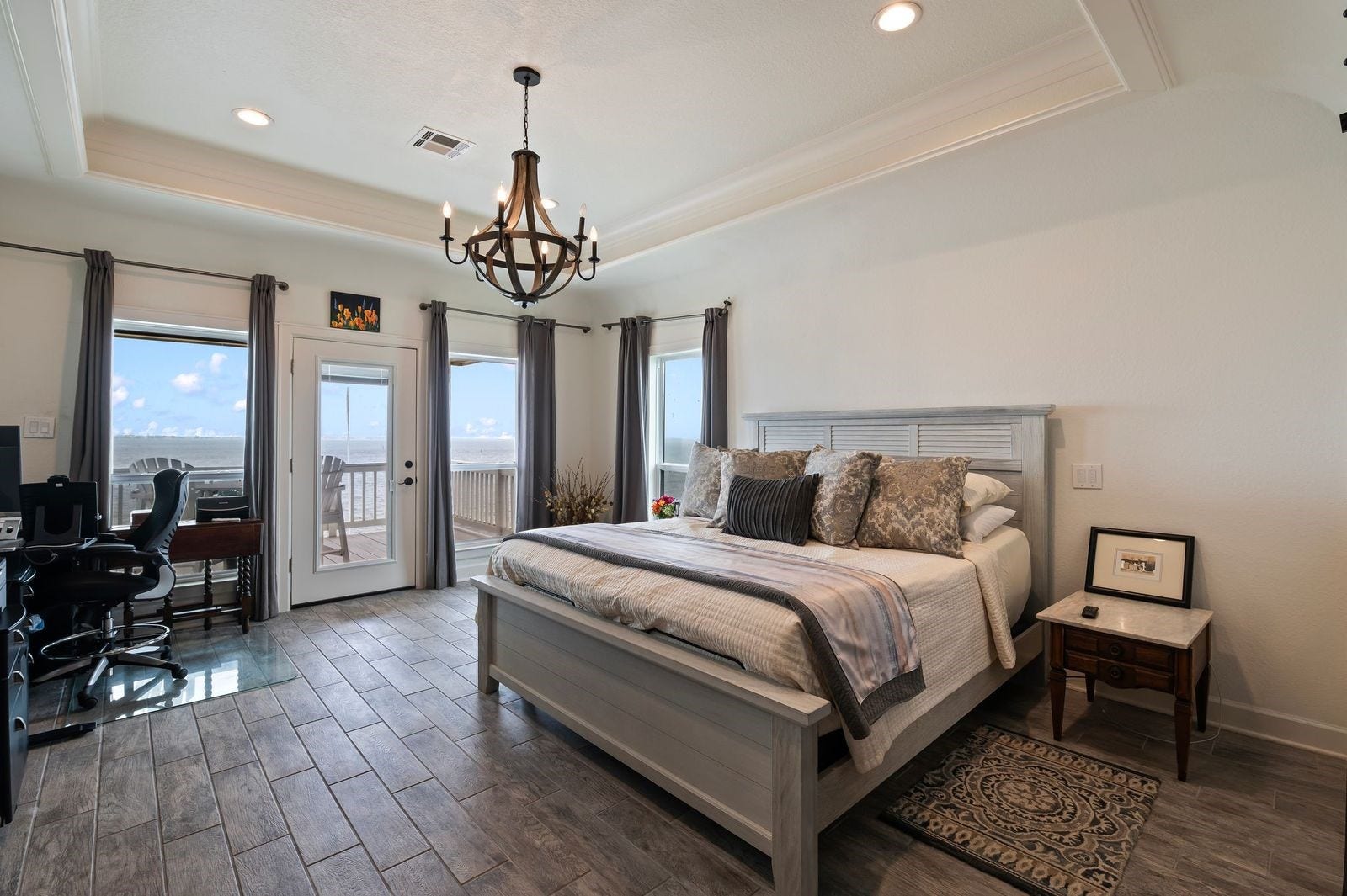 12 Tiki Circle, Tiki Island, TX 77554 Comfortable, Quiet, Luxury! Large Primary bedroom with private patio offering serene sunsets and amazing waterfront views.
