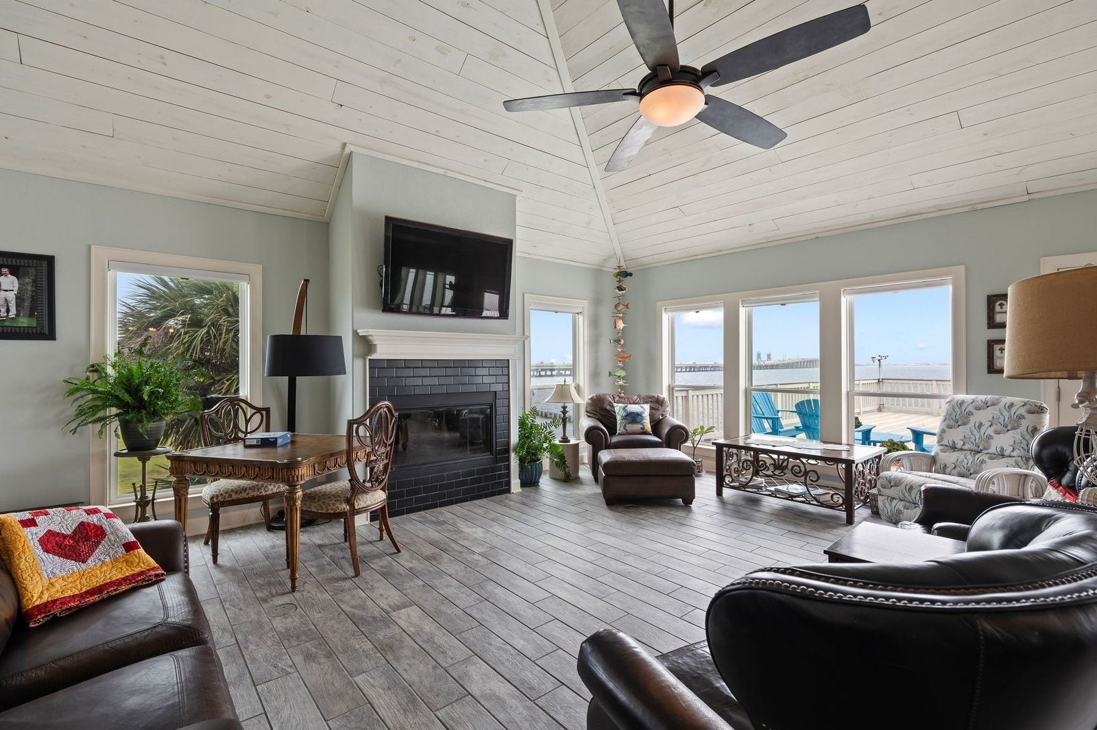 12 Tiki Circle, Tiki Island, TX 77554 Grand Living Spaces With Waterviews! Spacious living area with soaring cedar plank ceilings, fireplace and coastal wood-looking ceramic tile flooring.