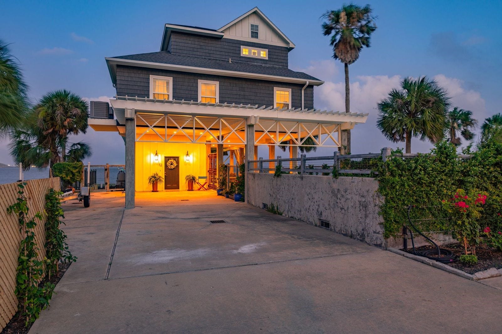 12 Tiki Circle, Tiki Island, TX 77554 Coastal New England Style Design & Perfect Location! Lush landscaping with extended parking areas and outdoor lighting.