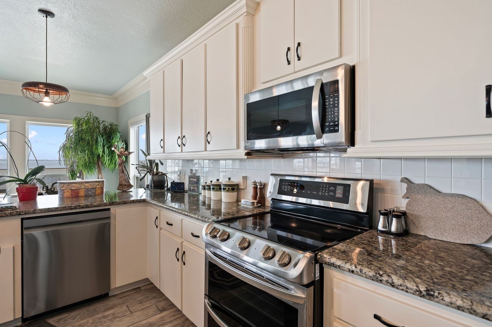 12 Tiki Circle, Tiki Island, TX 77554 Designer Style Living with double ovens, granite countertops and tile backsplash.
