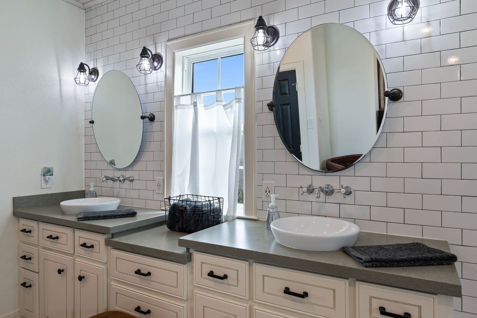 12 Tiki Circle, Tiki Island, TX 77554 Modern, Vibrant Beachside Beauty! A detailed view of the primary bathroom with custom fixtures, bowl sinks, subway tile backsplash and custom mirrors.