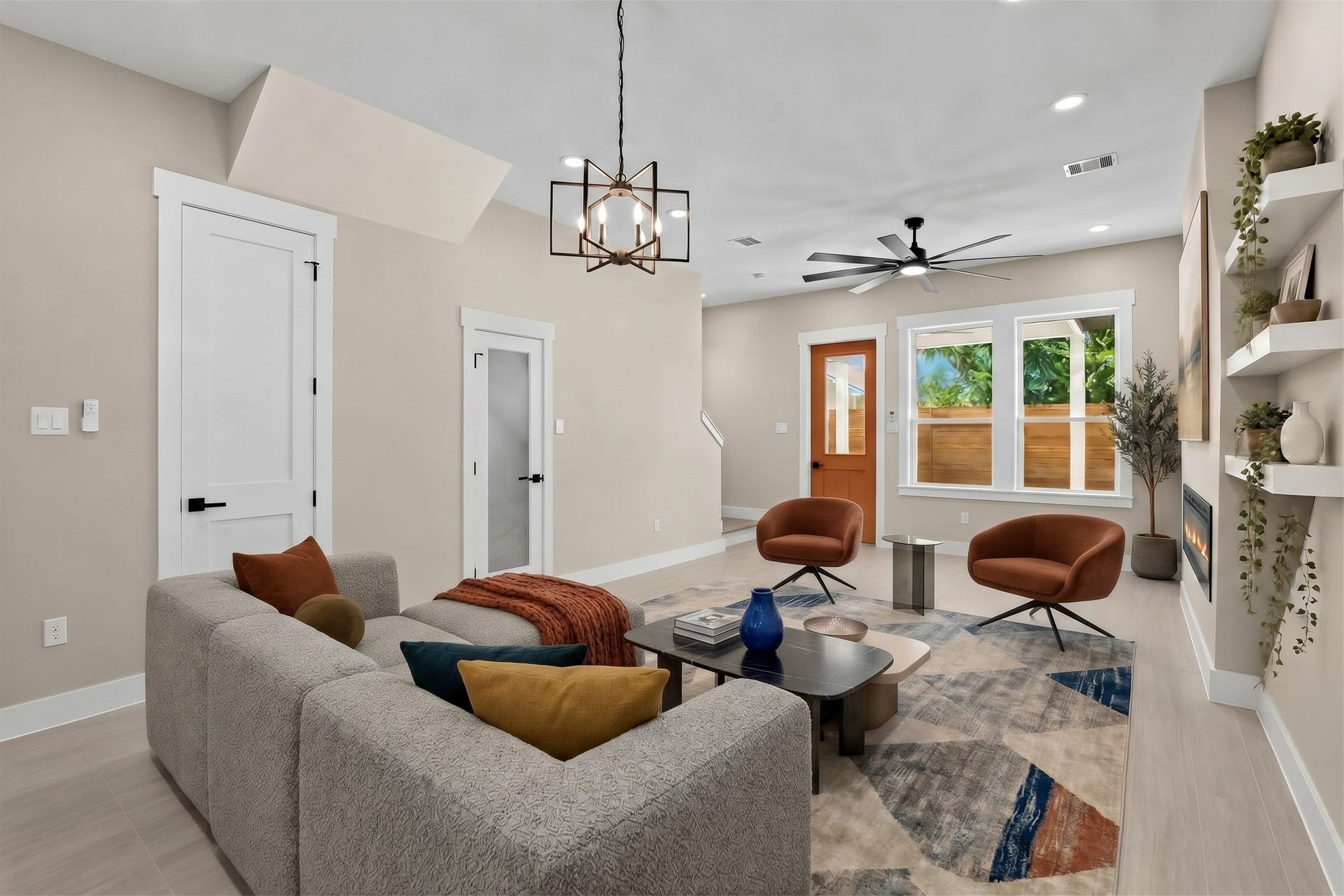 Virtually Staged: Large windows bring in abundant natural daylight, while floating wall shelves and an integrated fireplace elevate the overall aesthetic.