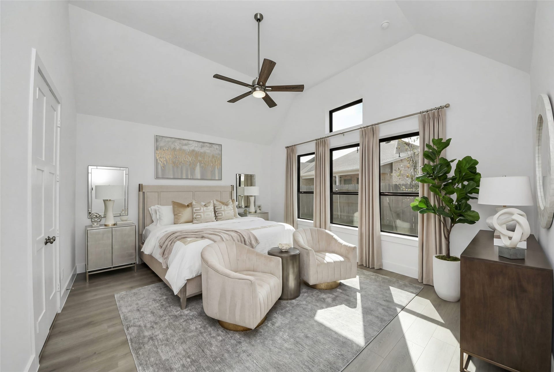 Relax and unwind after a long day in this impressive primary suite! This generously sized room offers laminate flooring, neutral-toned paint, high ceilings with a ceiling fan, and large windows for added comfort and tranquility.