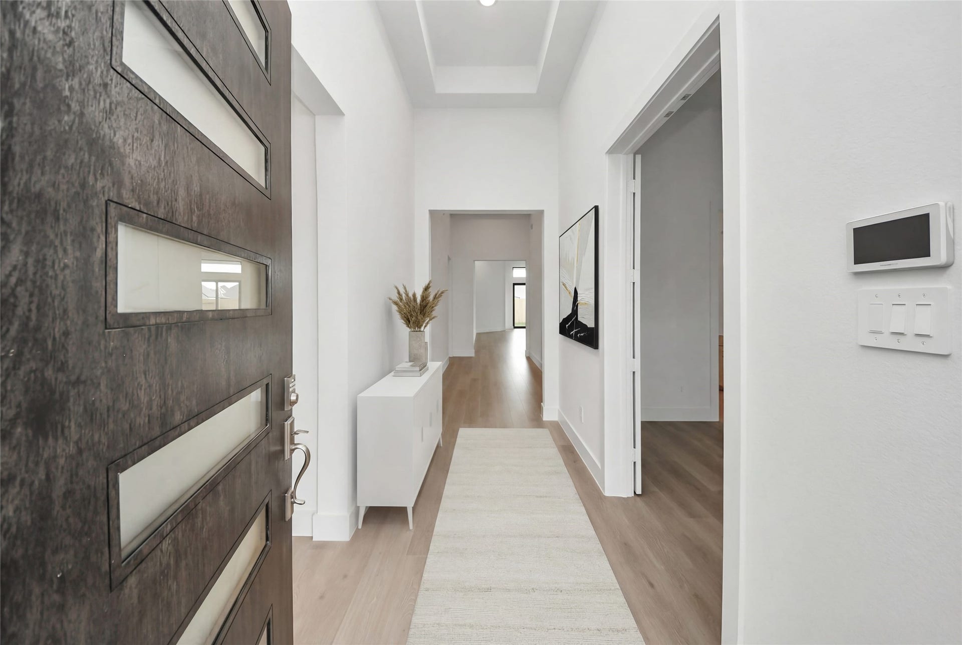 An inviting entrance opens up to an open-concept layout, seamlessly connecting the entry to the study and Great Room with durable laminate flooring and striking architectural details.