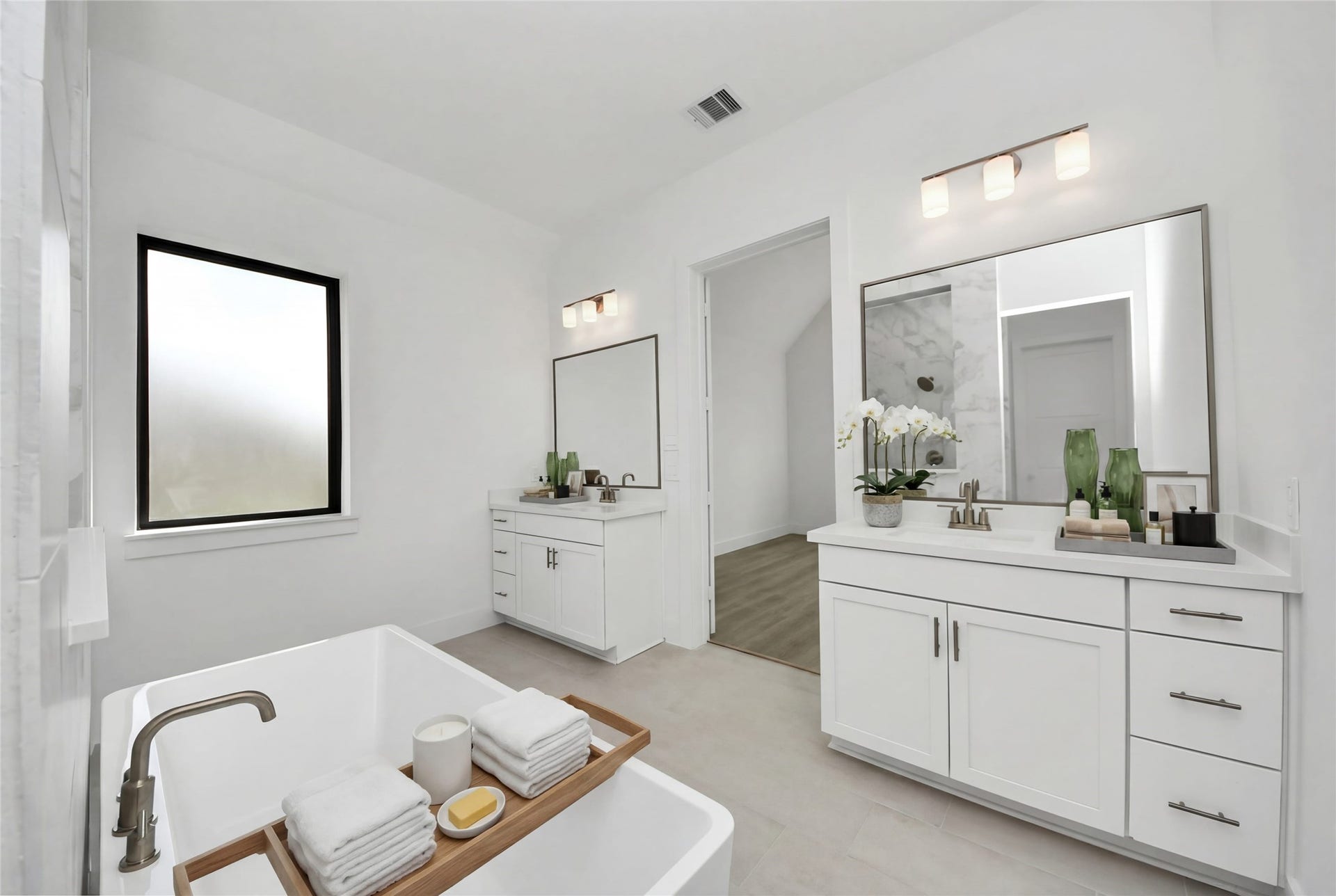 Modern primary bath features dual vanities with sleek cabinetry, quartz countertop, and brushed nickel fixtures for a truly contemporary feel.