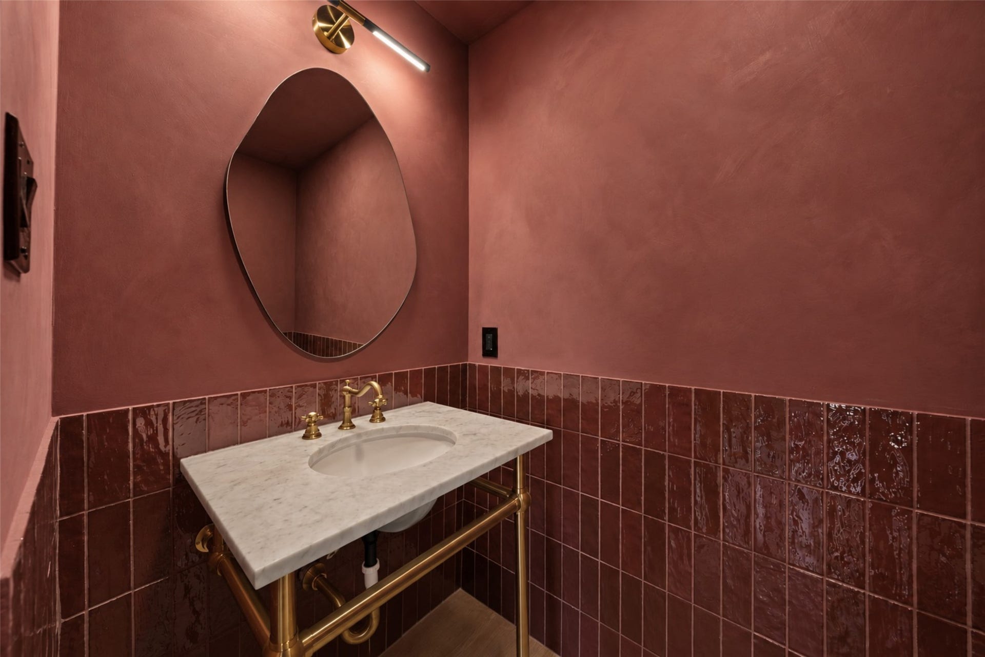 10111 Kerrwood Lane, Houston, TX 77080 The beautifully appointed powder bath makes a statement with a Pottery Barn washstand sink, striking tilework, and textured limewash walls.