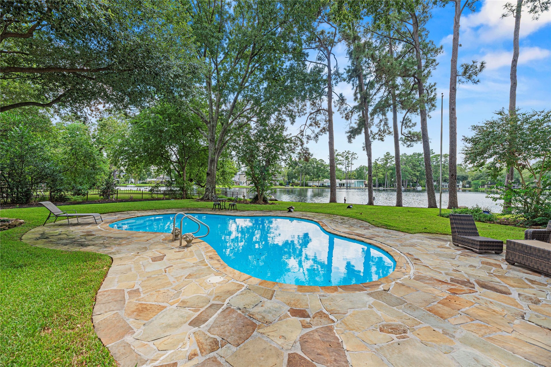 13131 Holston Hills Drive, Houston, TX 77069 Sparkling pool, expansive patio, lush green space, and 105' of lakefront.