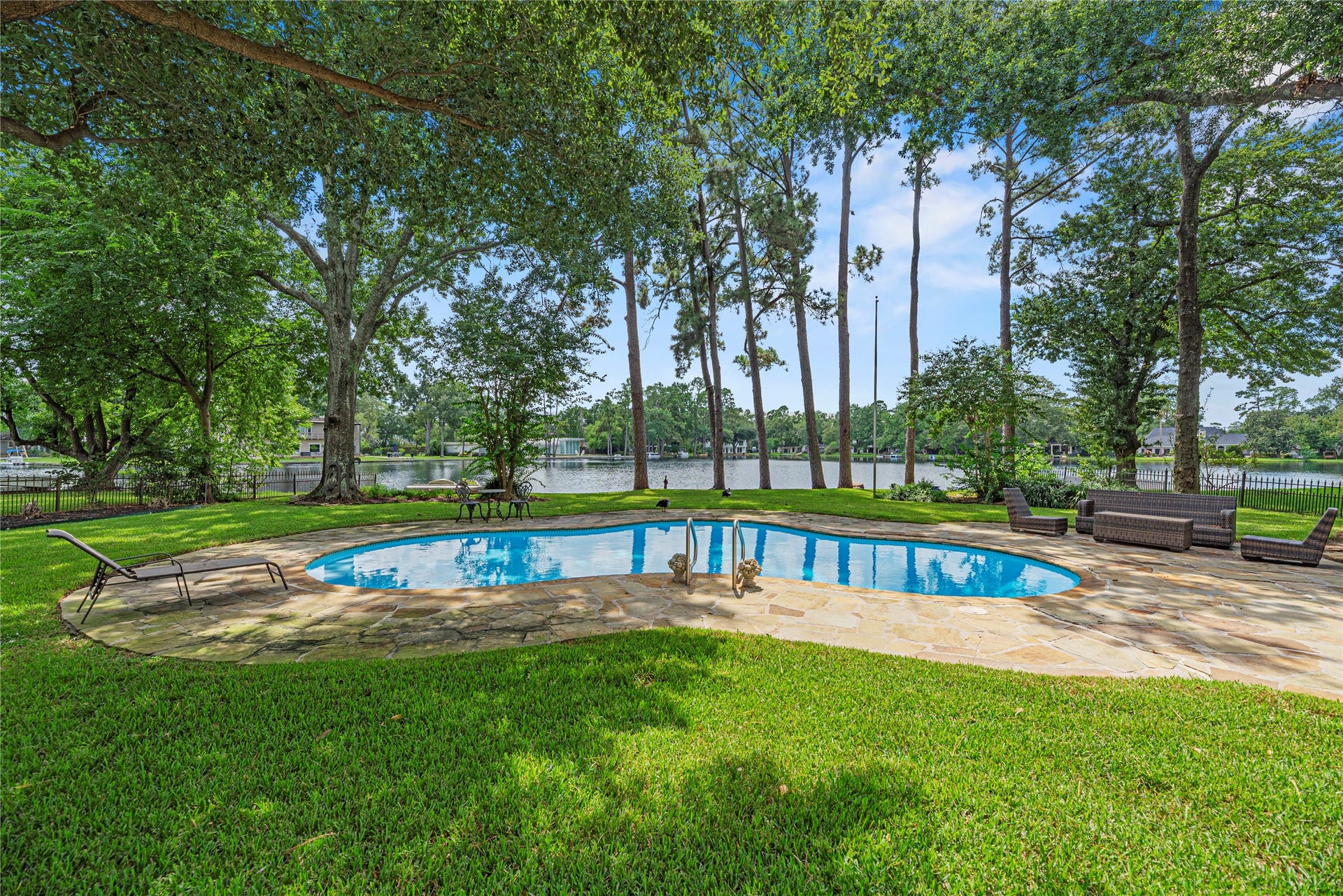 13131 Holston Hills Drive, Houston, TX 77069 Sparkling pool, expansive patio, lush green space, and 105' of lakefront.