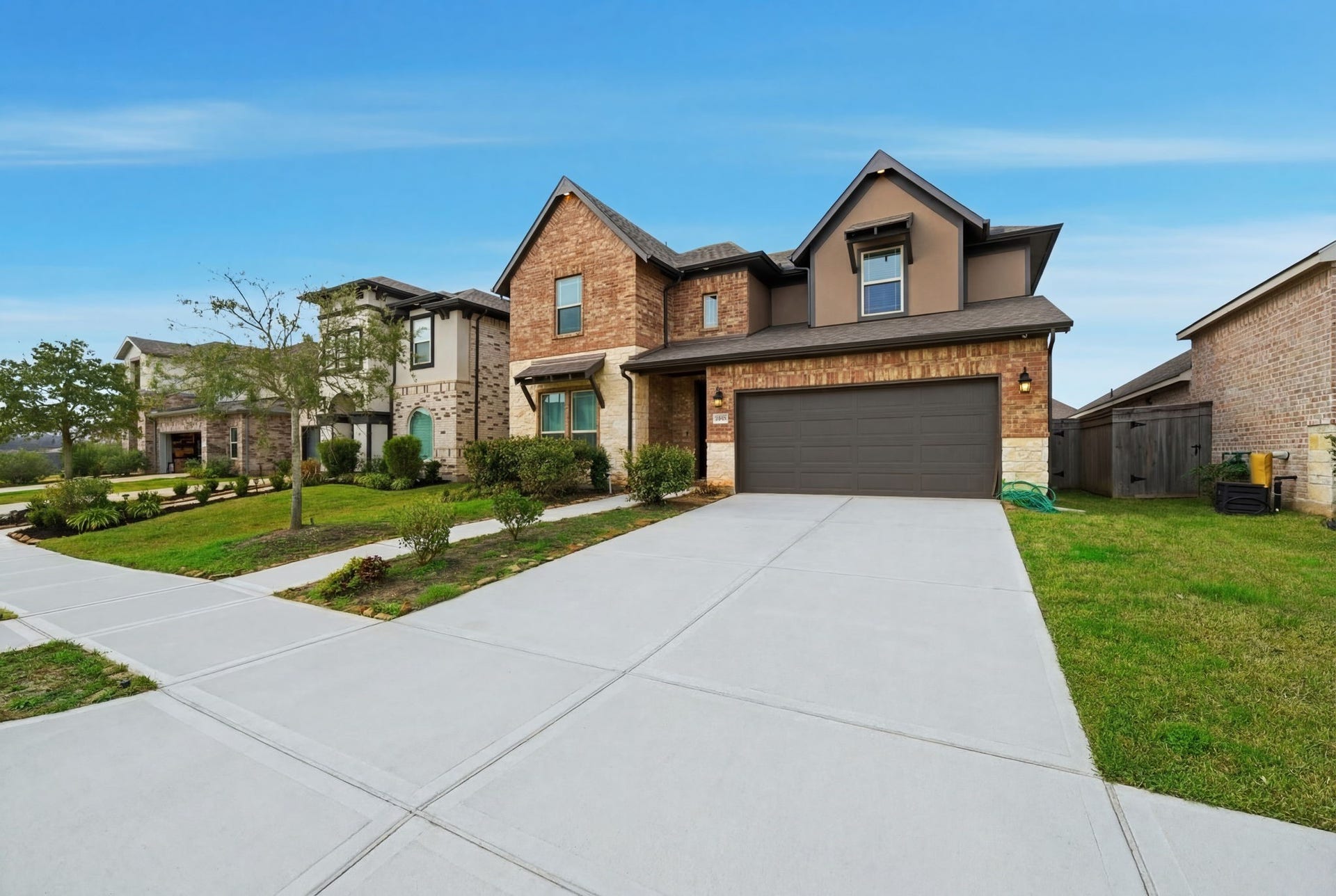 8815 Morning Glow Drive, Missouri City, TX 77459 This modern two-story home features a brick facade with contemporary accents, a spacious driveway, and a well-maintained front yard. It offers a large two-car garage and is situated in a suburban neighborhood with neatly lined sidewalks and manicured lawns.