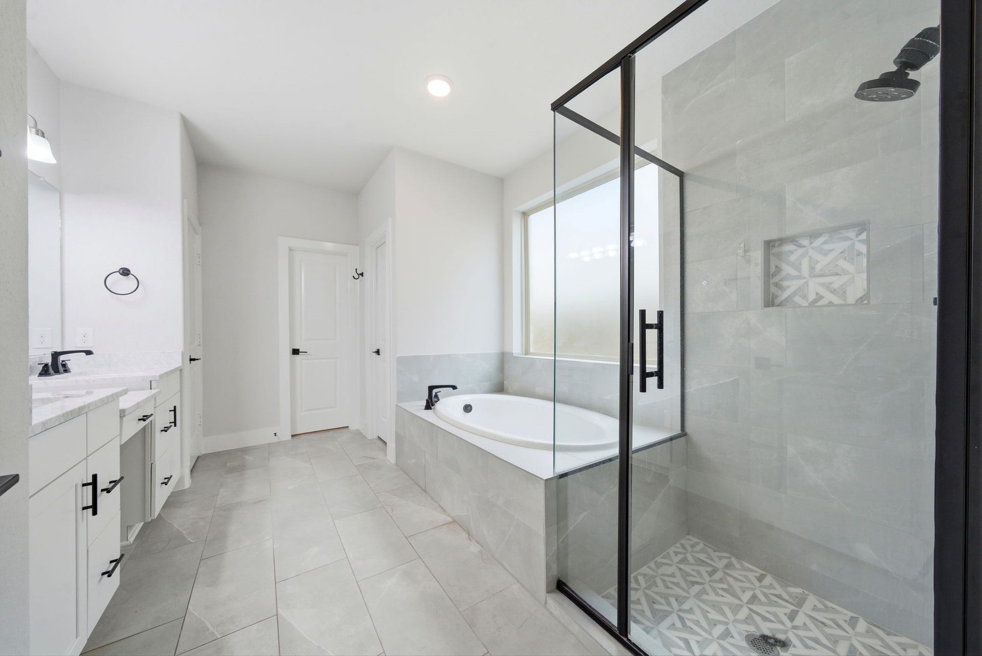 8815 Morning Glow Drive, Missouri City, TX 77459 This modern bathroom features a spacious layout with a glass-enclosed shower, a large bathtub, and dual sinks with sleek fixtures. The clean, neutral tones and ample natural light create an inviting and relaxing atmosphere.