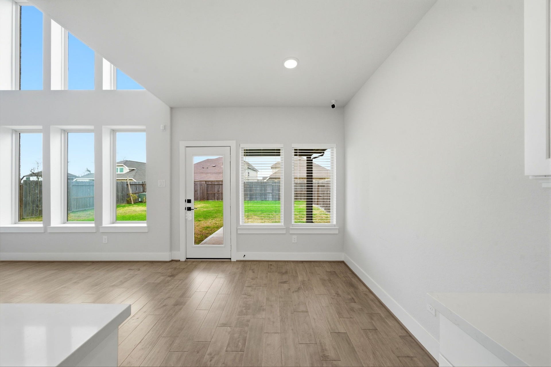8815 Morning Glow Drive, Missouri City, TX 77459 This bright, open living space features high ceilings and large windows, offering plenty of natural light and a view of the backyard. The neutral tones and hardwood flooring create a modern, inviting atmosphere.