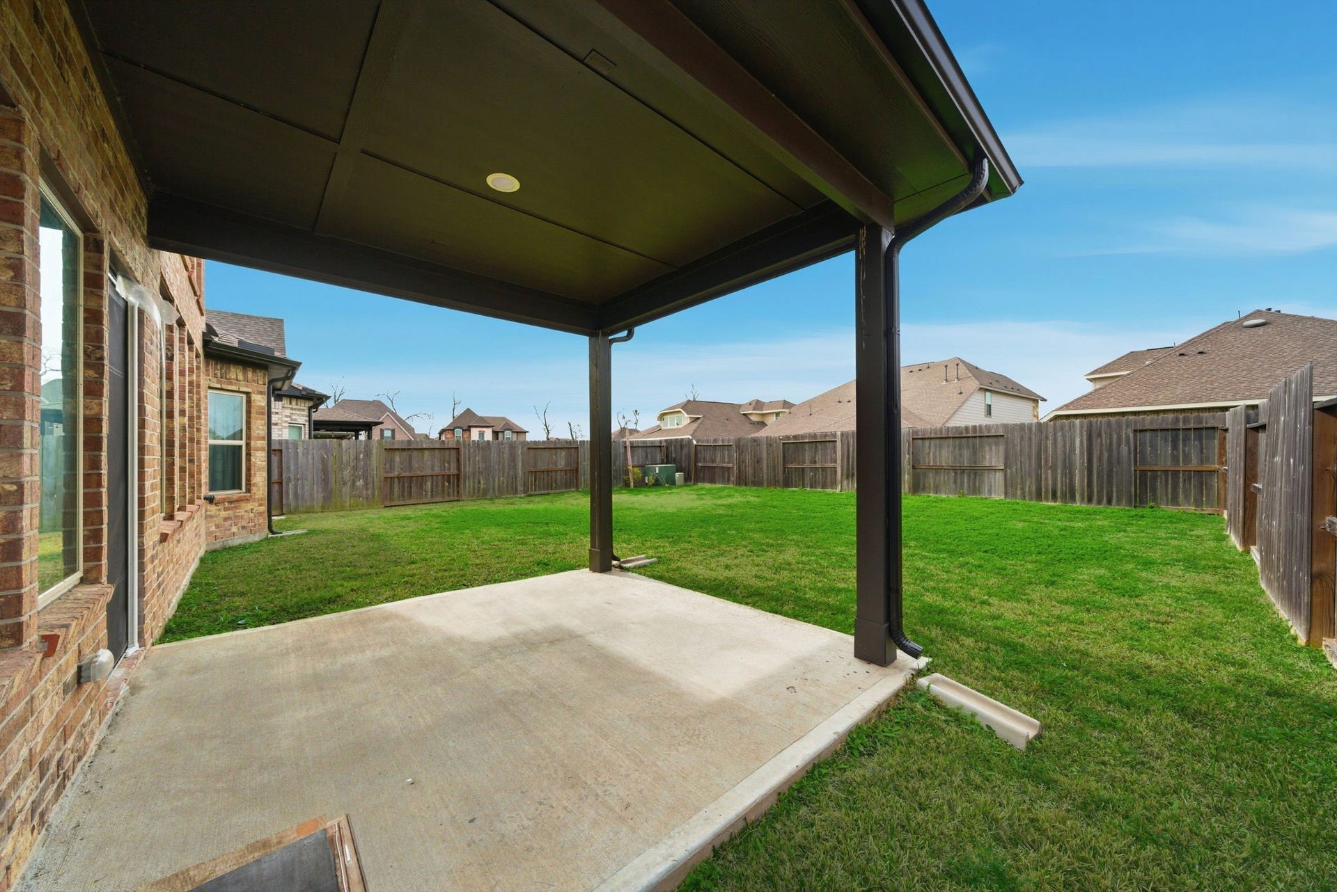 8815 Morning Glow Drive, Missouri City, TX 77459 Spacious backyard with a covered patio, perfect for outdoor relaxation and entertaining. The area is fenced, providing privacy and security.
