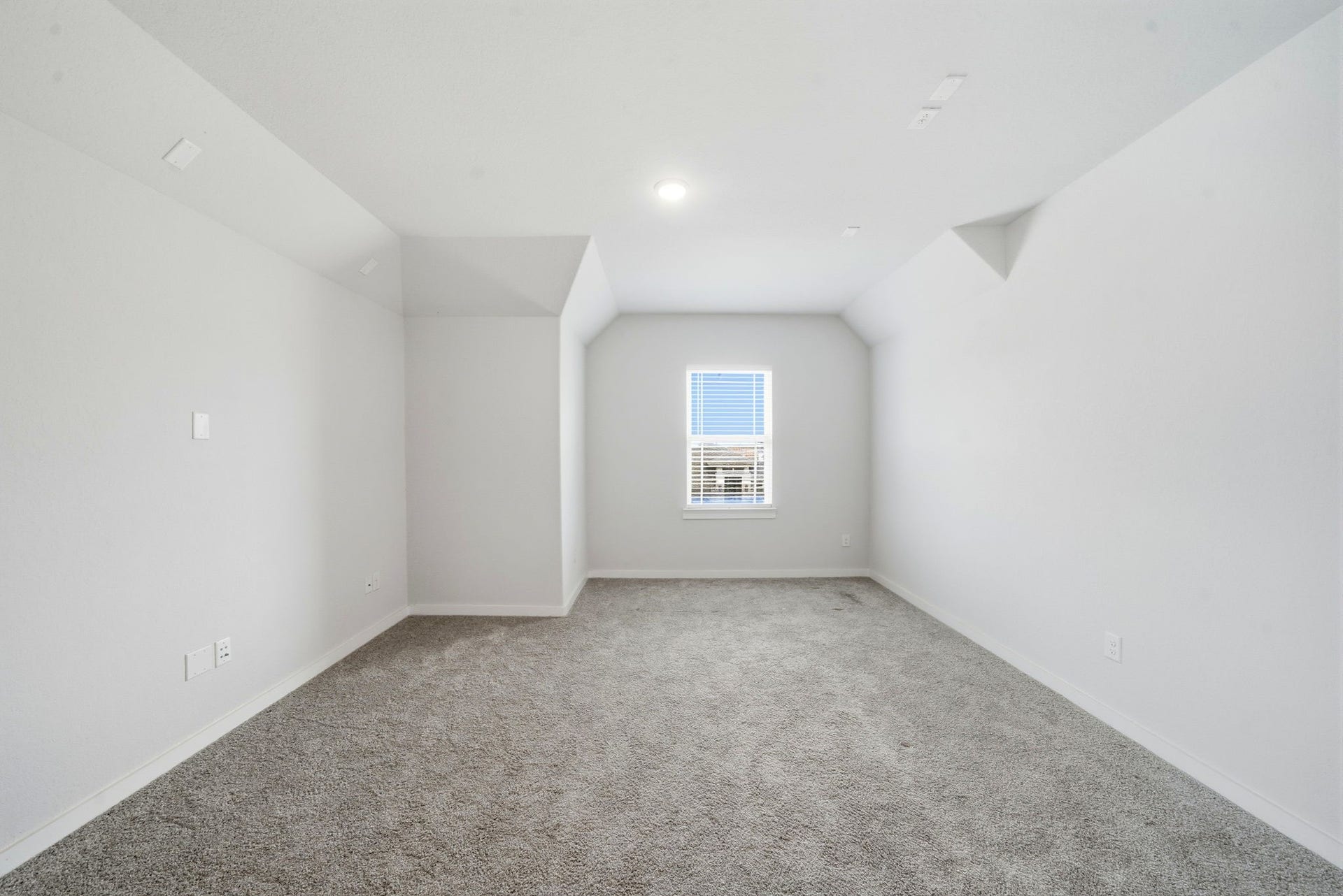 8815 Morning Glow Drive, Missouri City, TX 77459 Bright, neutral-toned room with plush carpet, featuring a central window providing natural light, and clean, angled ceiling lines. Ideal for customization.