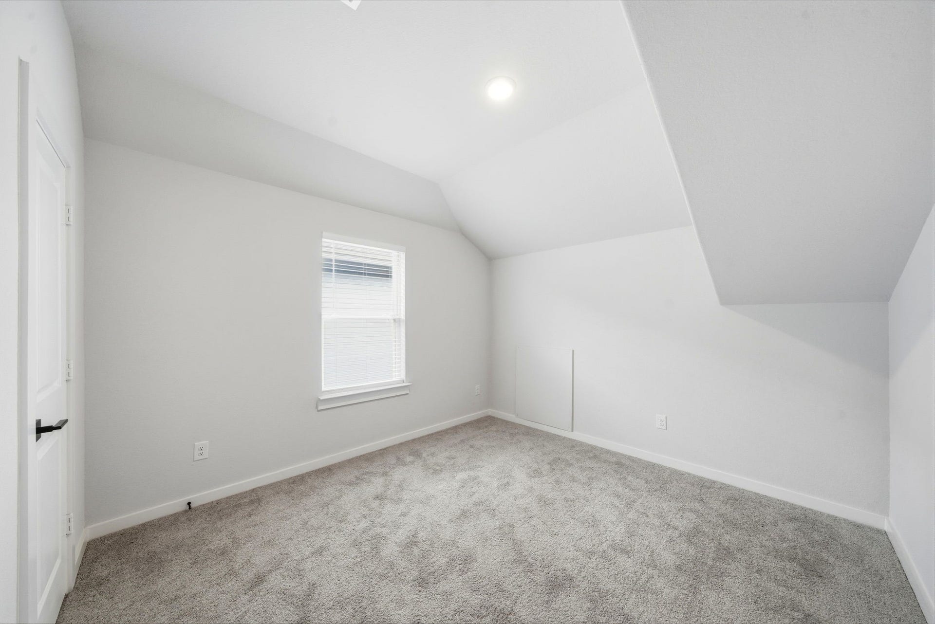 8815 Morning Glow Drive, Missouri City, TX 77459 This is a cozy, carpeted room with sloped ceilings, a single window, and neutral-colored walls, offering a bright and versatile space.