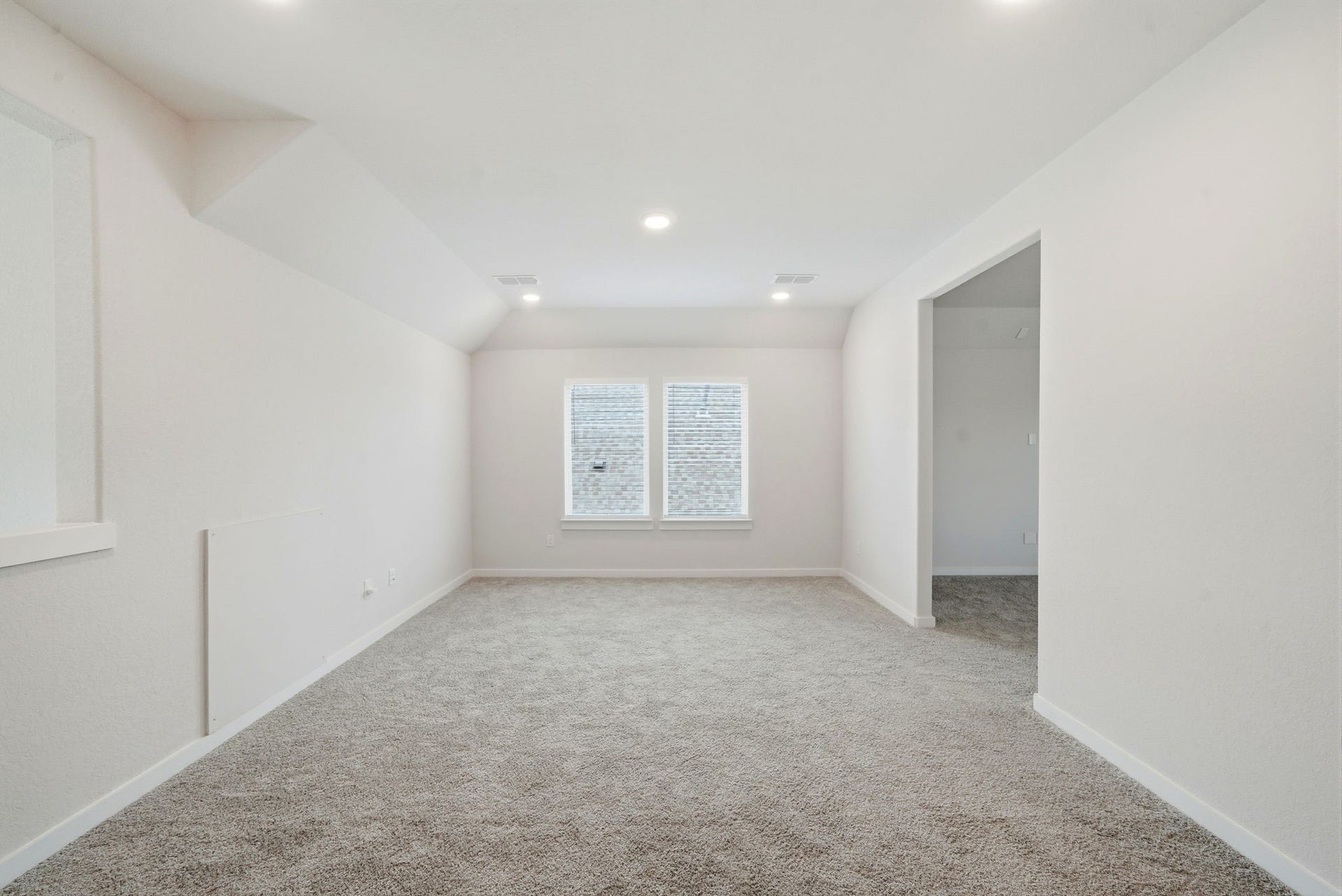 8815 Morning Glow Drive, Missouri City, TX 77459 This room is bright and spacious with neutral-colored walls and carpet, featuring recessed lighting and a window that brings in natural light. An open doorway leads to an adjoining space, offering versatility for various uses.