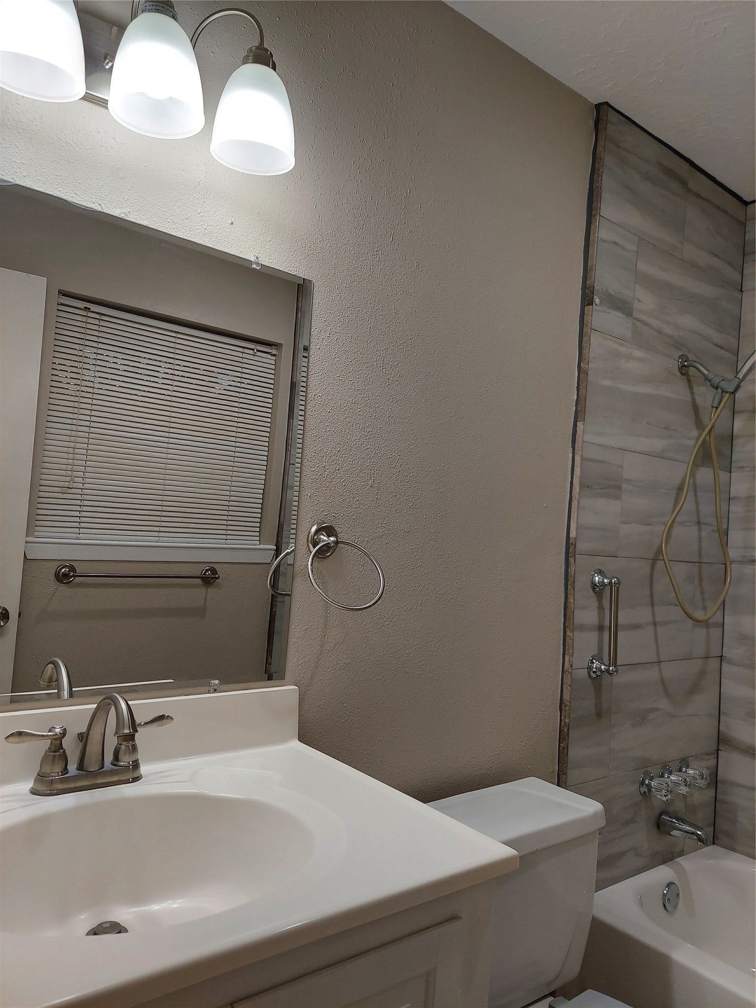3878 Laura Leigh Drive, Friendswood, TX 77546 Charming bathroom featuring a sleek vanity with modern fixtures, a cozy tub with tiled walls, and soft lighting enhancing the serene ambiance.