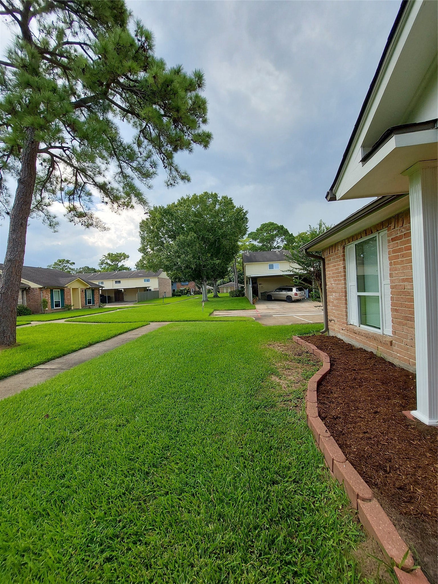 3878 Laura Leigh Drive, Friendswood, TX 77546 Charming brick home with a well-maintained lawn, mature trees, and a welcoming front pathway in a peaceful neighborhood setting.