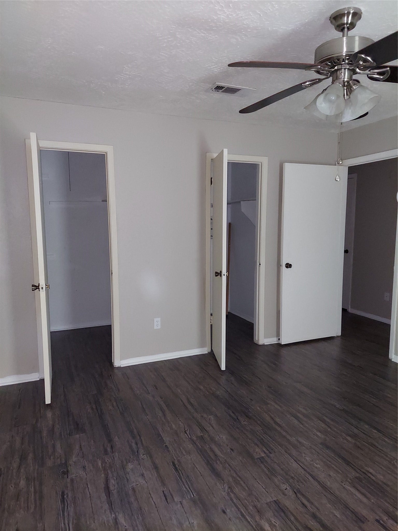 3878 Laura Leigh Drive, Friendswood, TX 77546 Spacious room with elegant dark wood flooring, a modern ceiling fan, and ample closet space for storage.