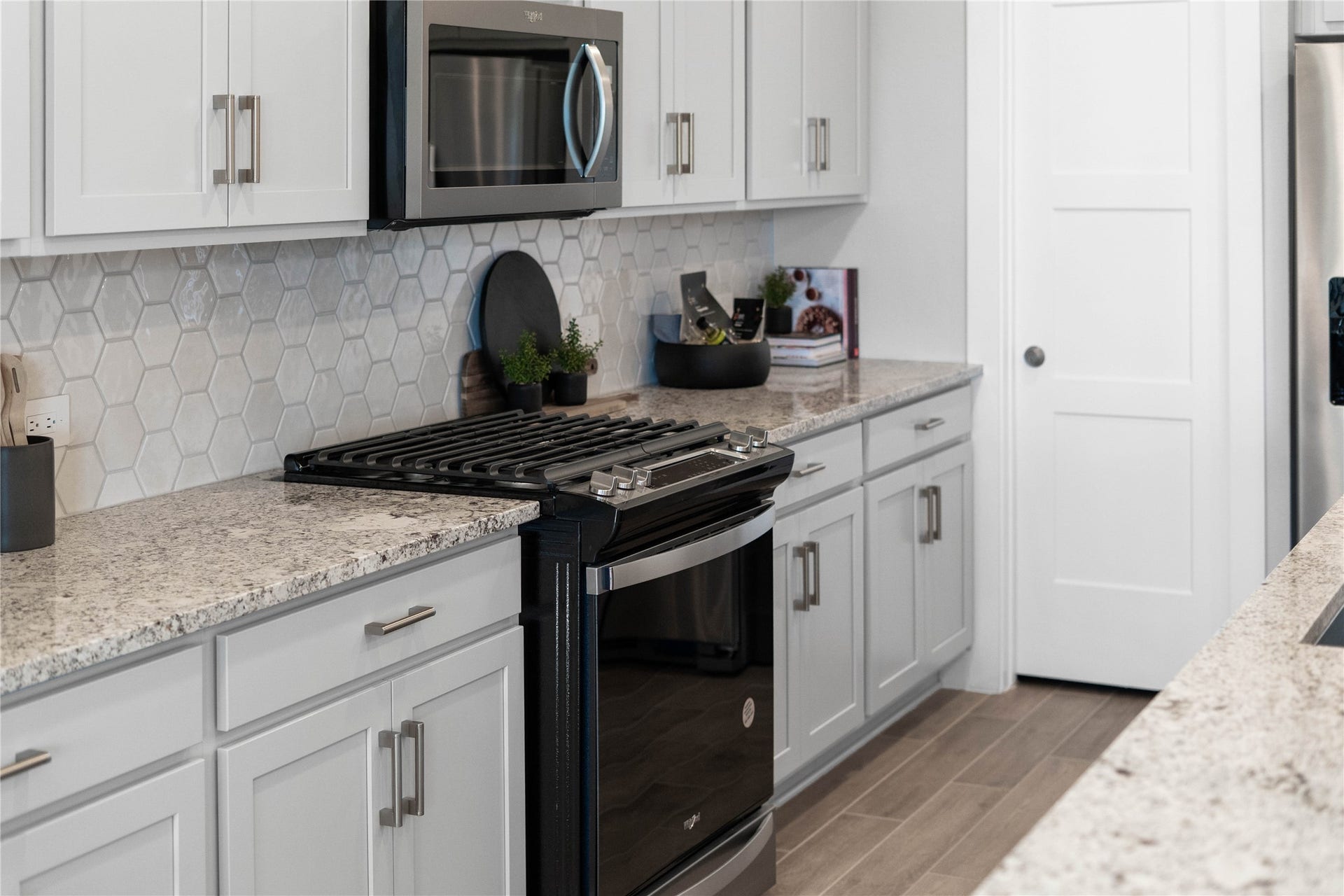 19608 Montgomery Ridge Way, Montgomery, TX 77316 Showcased here is a Whirlpool gas range, paired with a steam microwave equipped with sensor cookingall framed by an elegant tile backsplash.