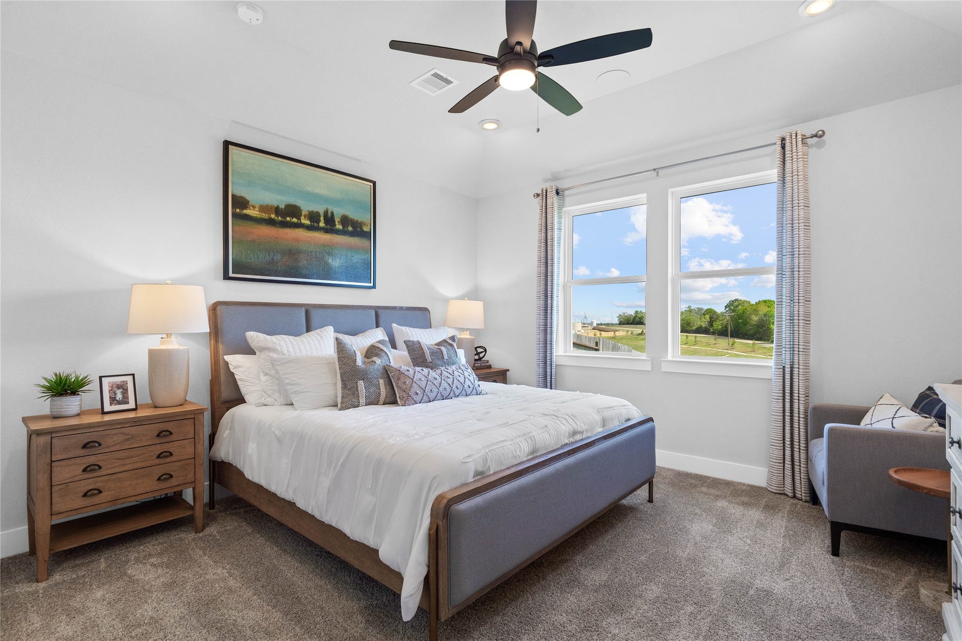 19608 Montgomery Ridge Way, Montgomery, TX 77316 The primary bedroom provides a peaceful escape with a bright, neutral palette, sloped ceilings, ceiling fan large windows, and plush carpet flooring, creating a calm and restorative atmosphere to end your day.