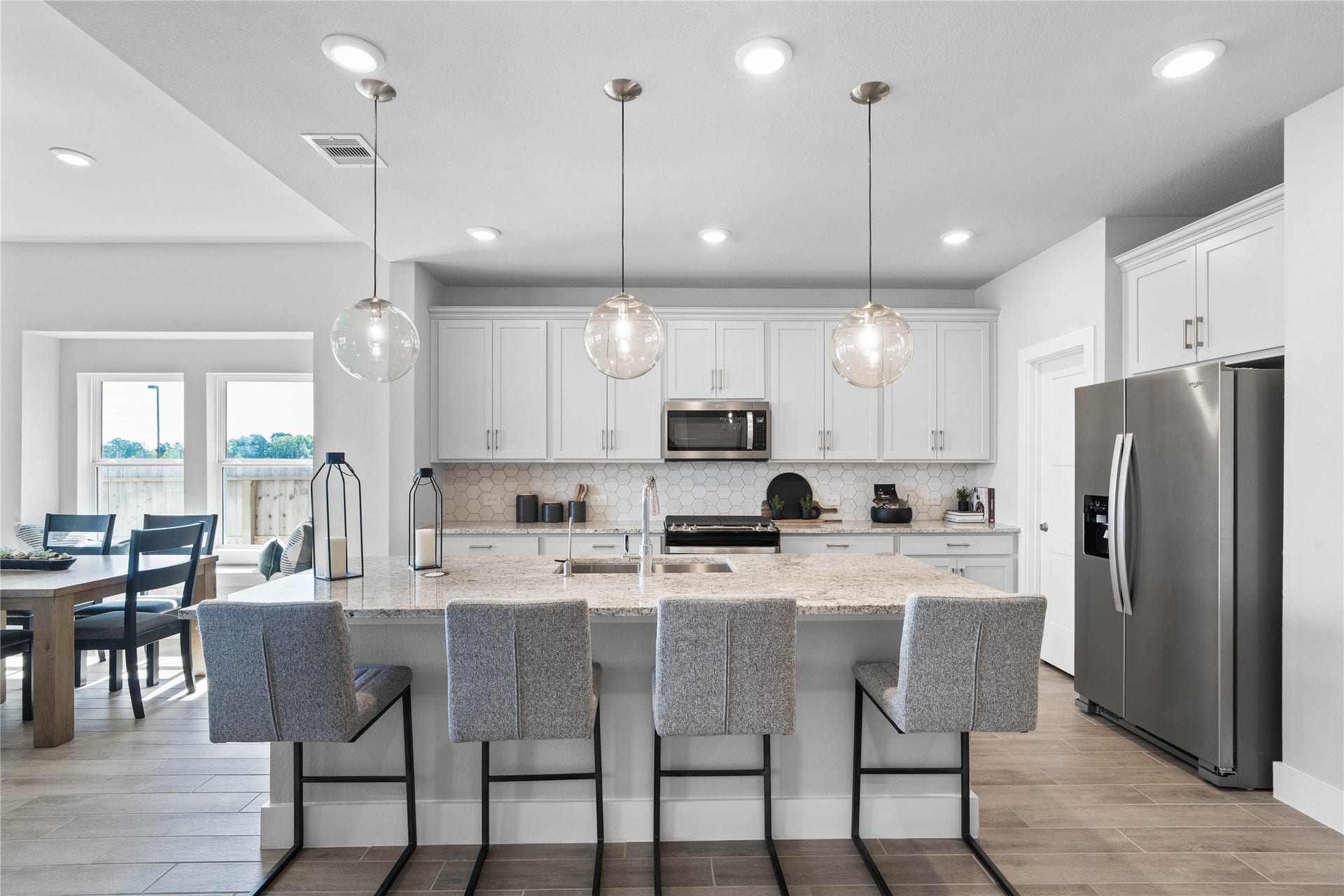 19608 Montgomery Ridge Way, Montgomery, TX 77316 This modern kitchen island features a polished granite countertop with an undermount stainless steel sink, complemented by a Moen Sleek chrome faucet with DuPure water filtration system.